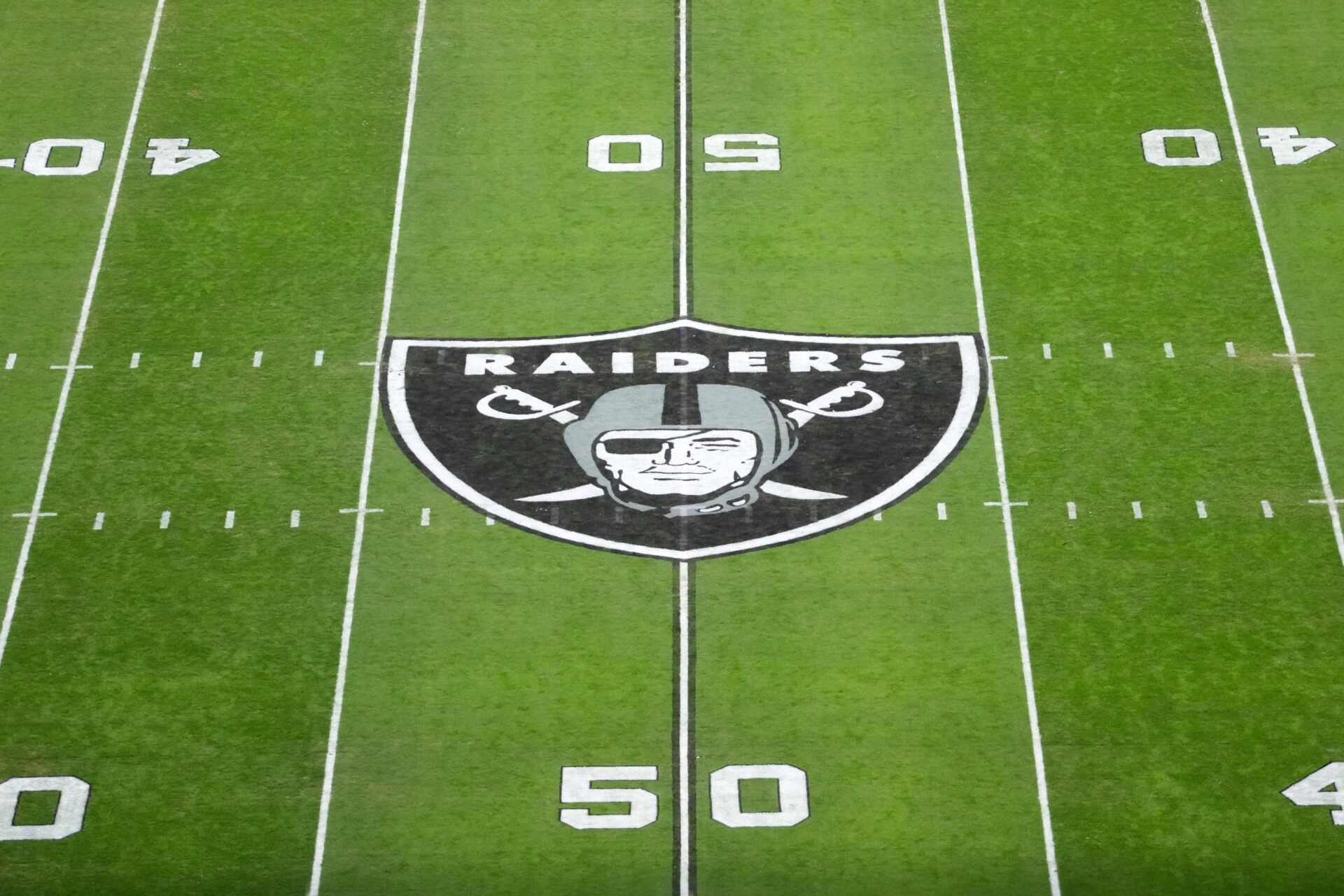 The Las Vegas Raiders shield logo at midfield at Allegiant Stadium.