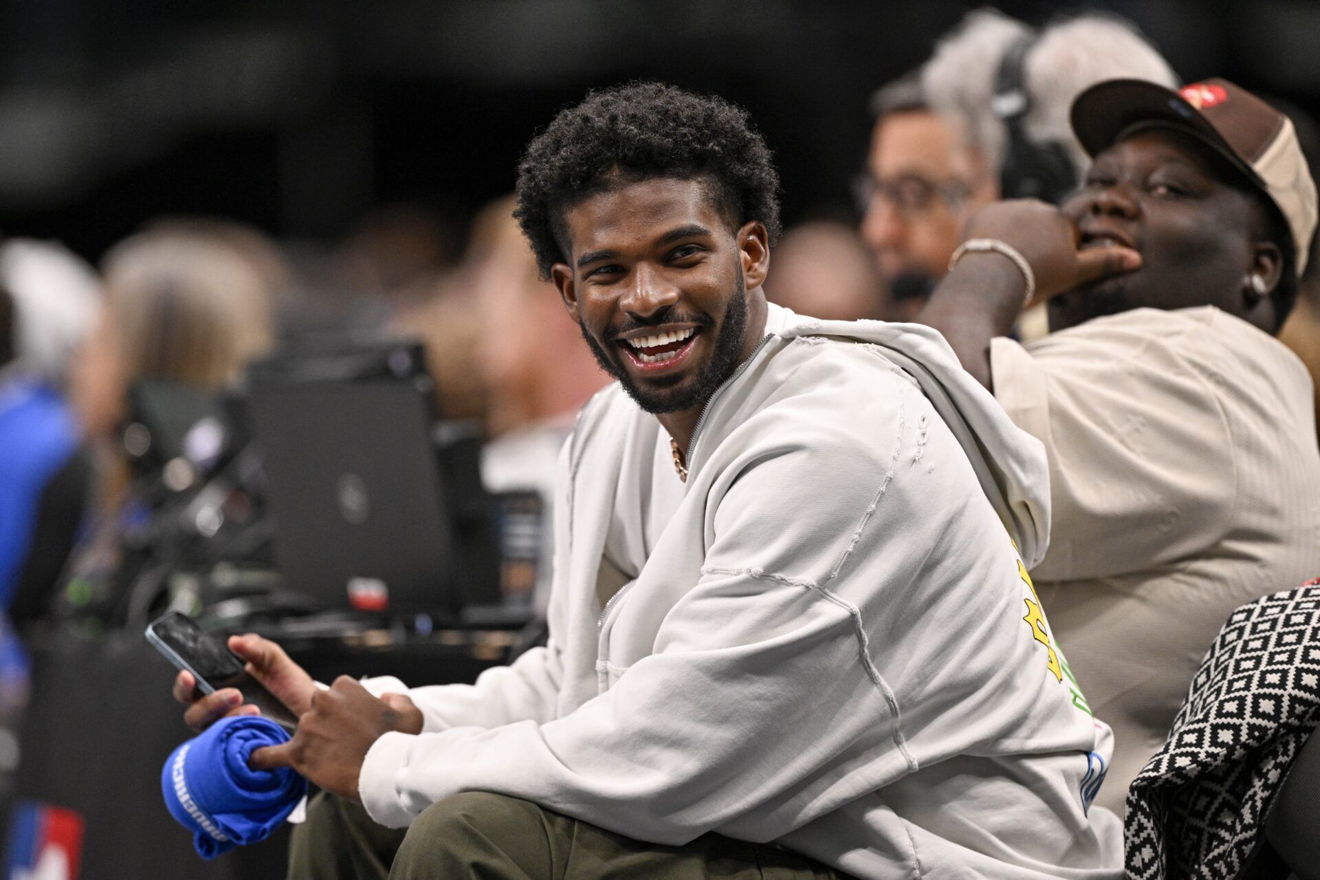 Colorado Buffaloes quarterback Shedeur Sanders laughs as he watches the game between the Dallas Mavericks and the Denver Nuggets during the second half at the American Airlines Center.