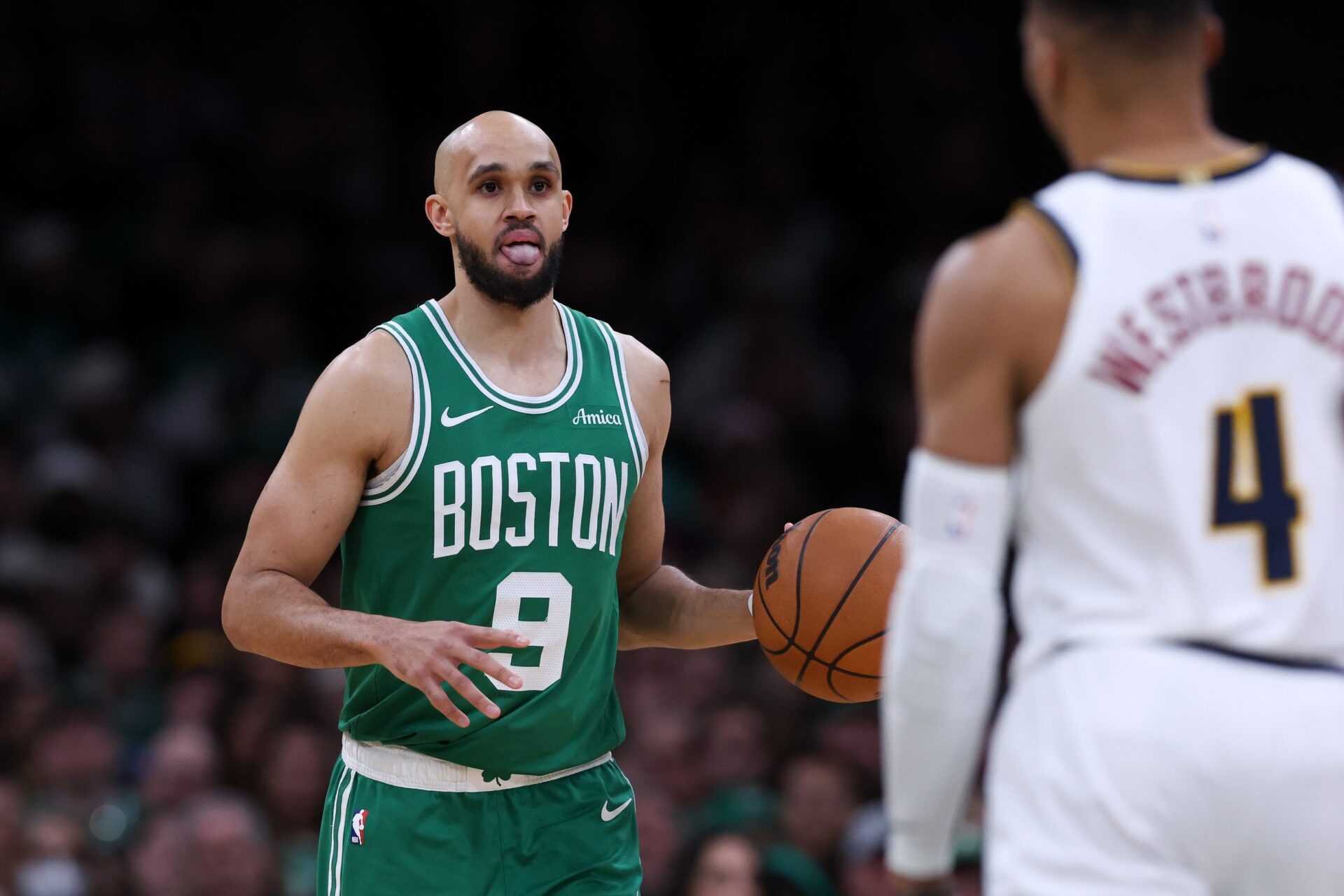 Boston Celtics guard Derrick White (9) dribbles down the court during the second half against the Denver Nuggets at TD Garden.