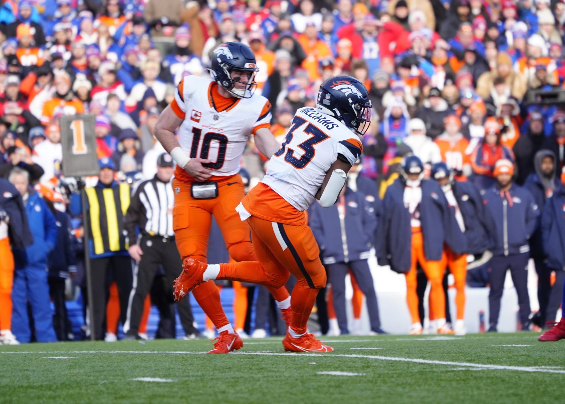 Denver Broncos quarterback Bo Nix (10) hands the ball off to Denver Broncos running back Javonte Williams (33) during the third quarter against the Buffalo Bills in an AFC wild card game at Highmark Stadium.
