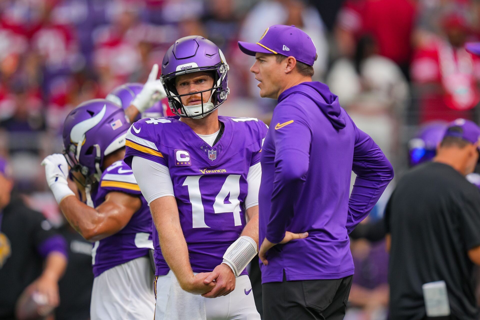 Minnesota Vikings quarterback Sam Darnold (14) and head coach Kevin O'Connell talk before the game against the San Francisco 49ers at U.S. Bank Stadium.