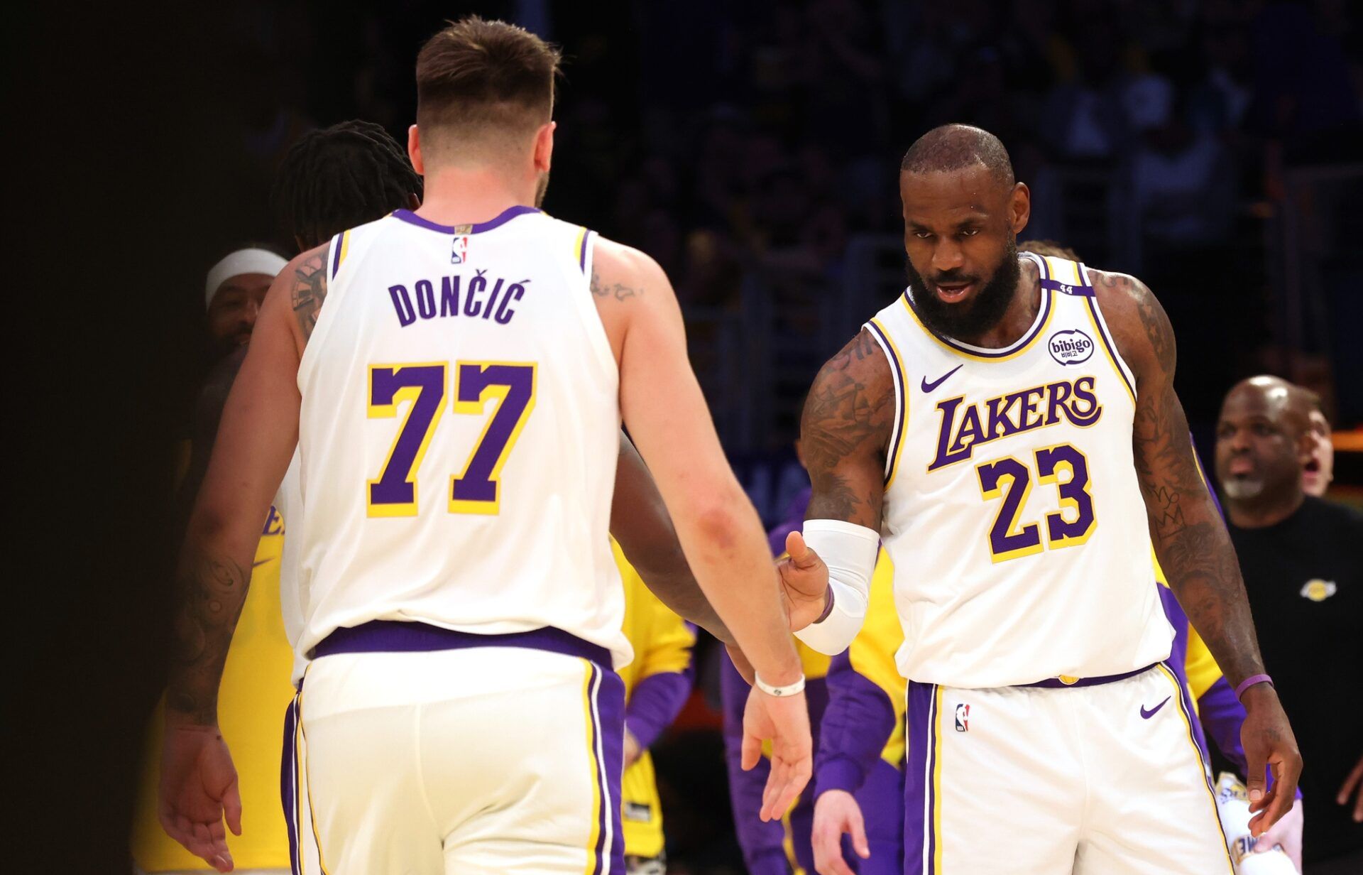 Los Angeles Lakers forward LeBron James (23) and guard Luka Doncic (77) react after a play during the first quarter against the LA Clippers at Crypto.com Arena.