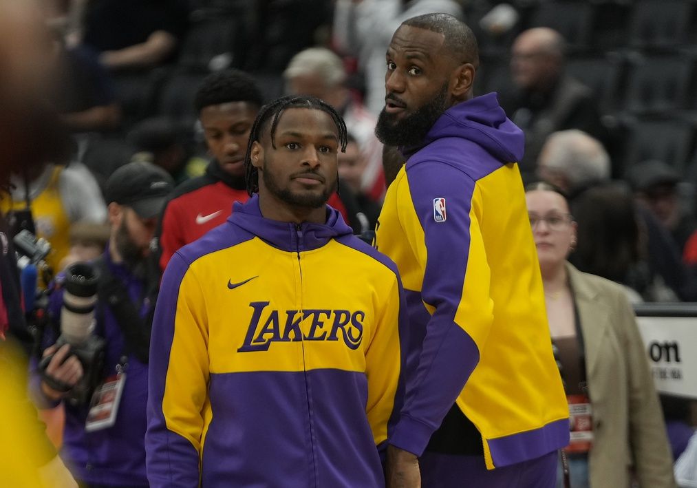 Los Angeles Lakers forward LeBron James (right) looks back at guard Bronny James (left) warm-up before the start of the game against the Toronto Raptors at Scotiabank Arena.