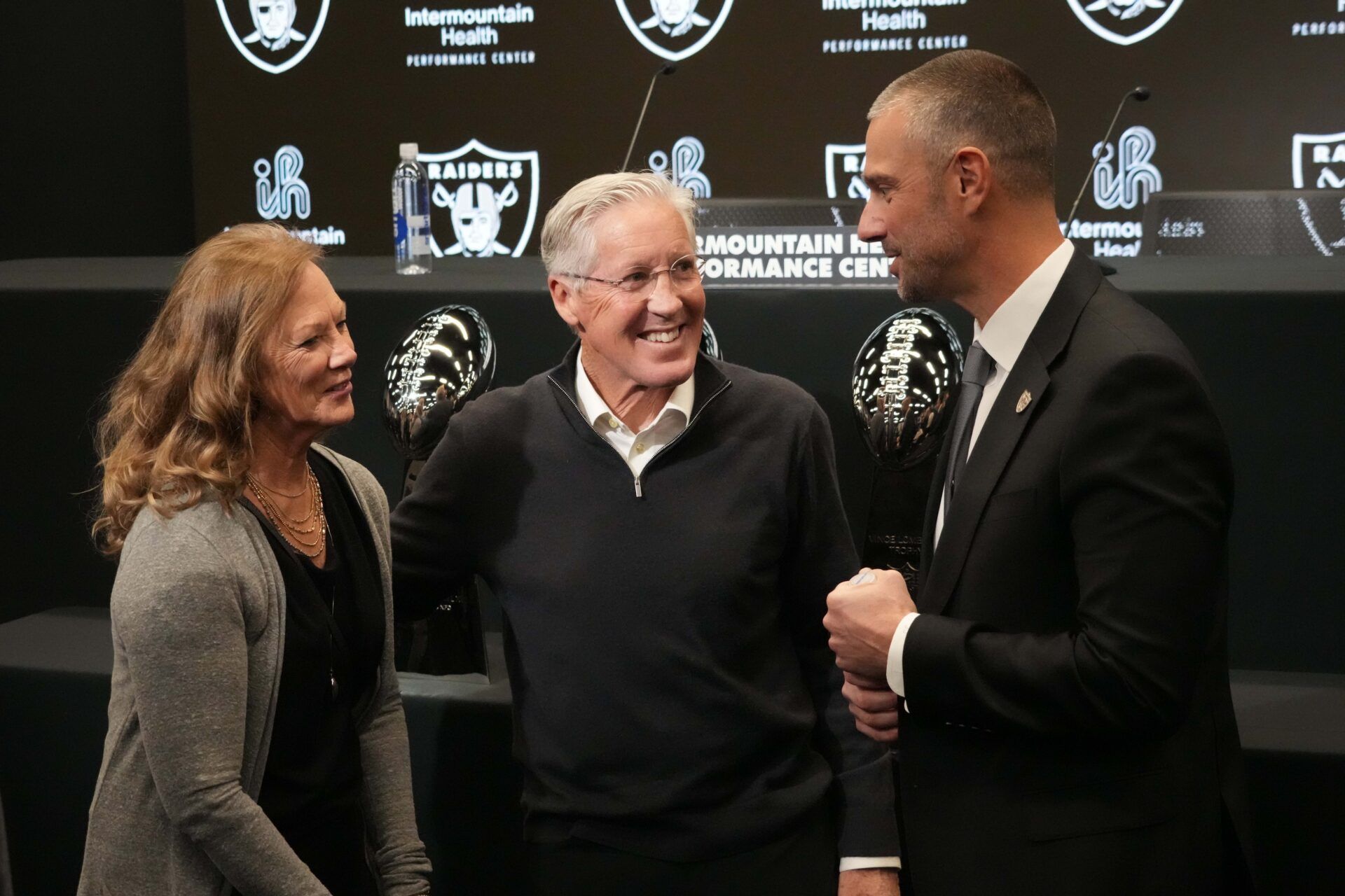 Las Vegas Raiders coach Pete Carroll (center) with wife Glena Goranson (left) and general manager John Spytek at press conference at Intermountain Health Performance Center.