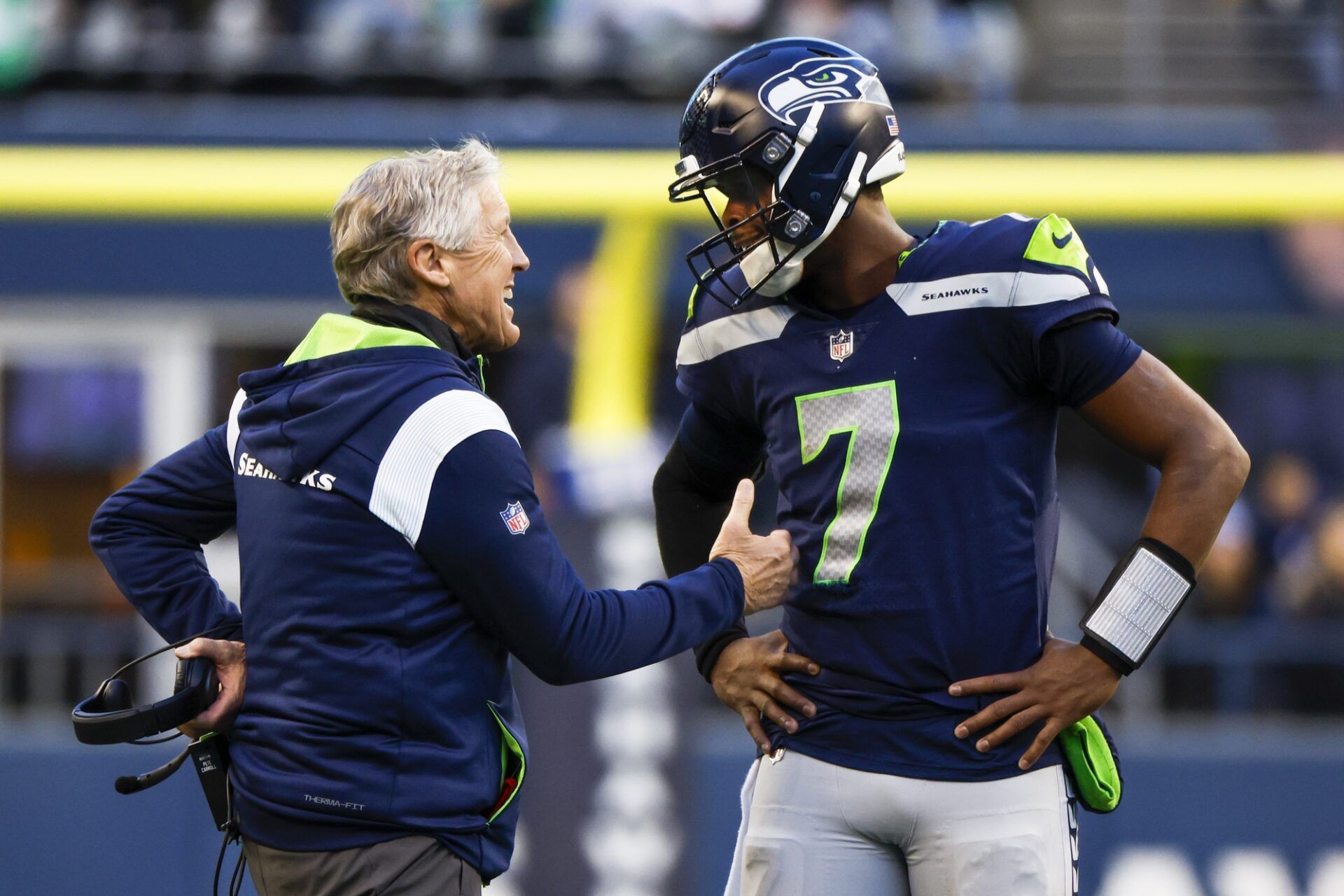 Seattle Seahawks head coach Pete Carroll, left, talks with quarterback Geno Smith (7) during a fourth quarter timeout against the New York Jets at Lumen Field.