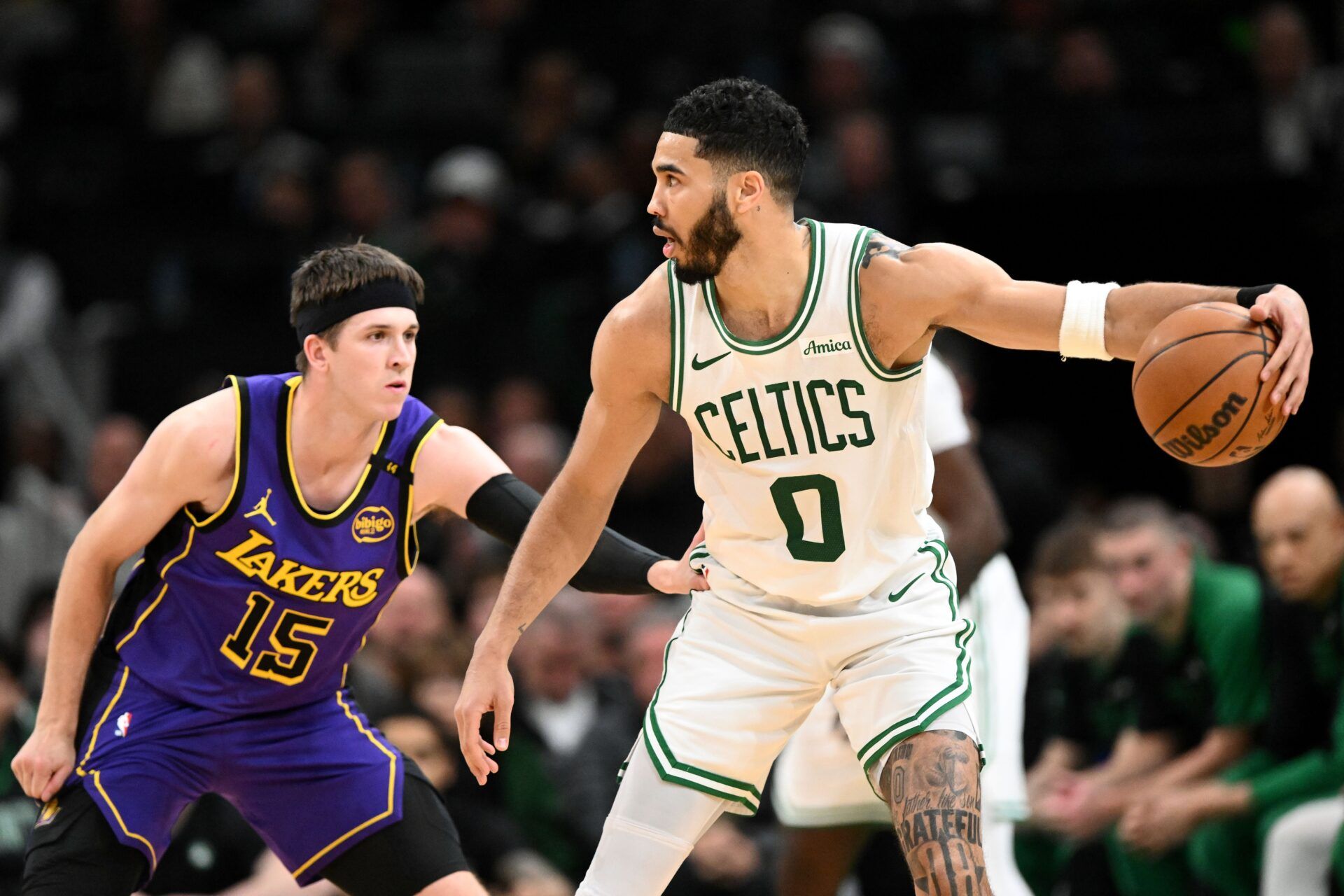 Boston Celtics forward Jayson Tatum (0) dribbles the ball against Los Angeles Lakers guard Austin Reaves (15) during the second quarter at the TD Garden.