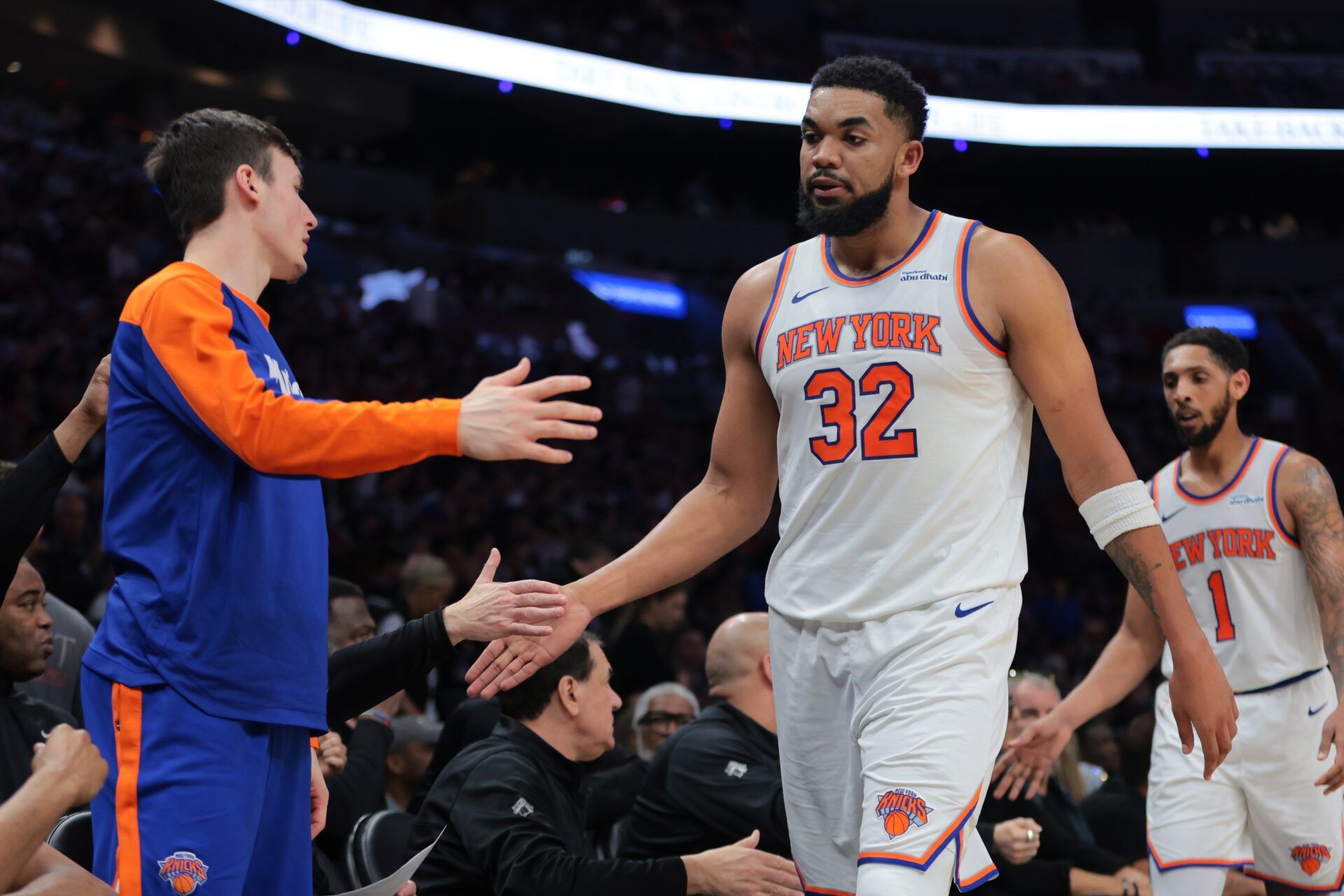 New York Knicks center Karl-Anthony Towns (32) high-fives with teammates during the second quarter against the Miami Heat at Kaseya Center.