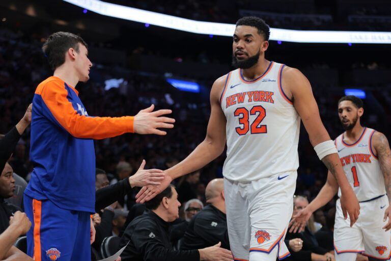 New York Knicks center Karl-Anthony Towns (32) high-fives with teammates during the second quarter against the Miami Heat at Kaseya Center.