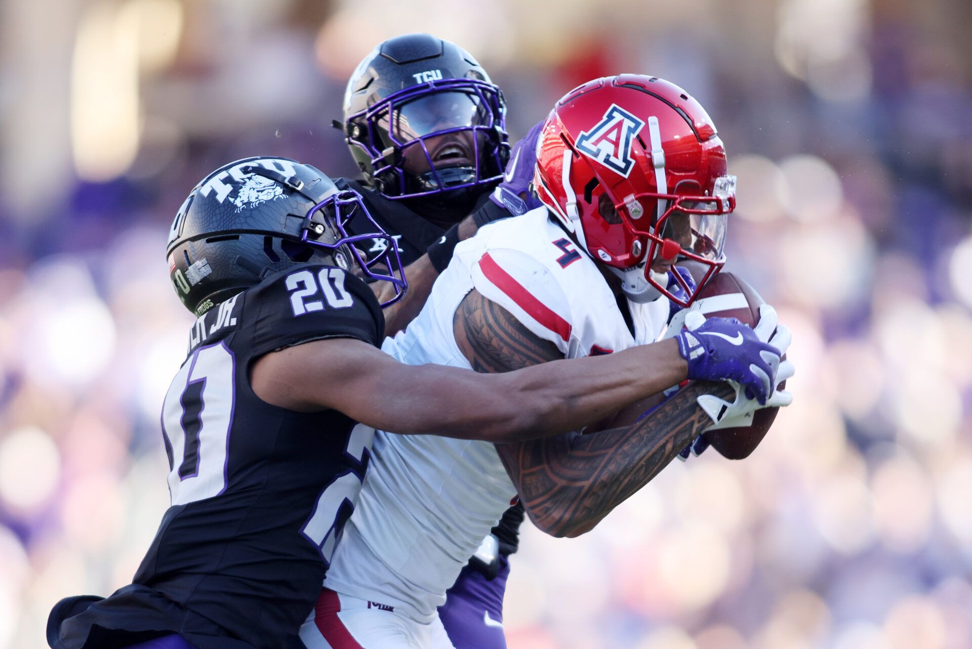 Nov 23, 2024; Fort Worth, Texas, USA; Arizona Wildcats wide receiver Tetairoa McMillan (4) catches a pass against TCU Horned Frogs cornerback Jevon McIver Jr. (20) and safety Jamel Johnson (2) in the second quarter at Amon G. Carter Stadium. Mandatory Credit: Tim Heitman-Imagn Images