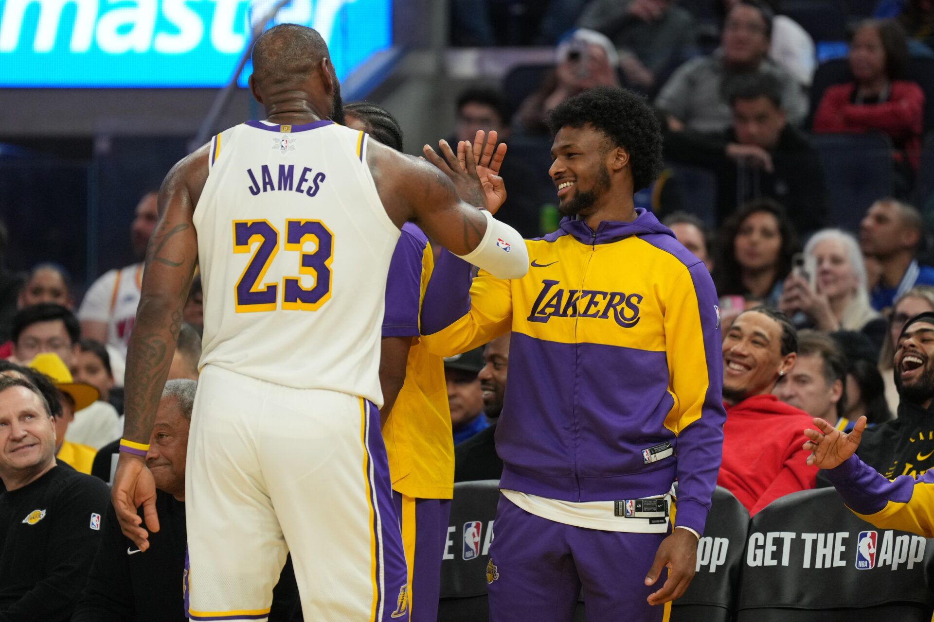 Los Angeles Lakers forward LeBron James (23) slaps hands with guard Bronny James (center right) during the third quarter against the Golden State Warriors at Chase Center.