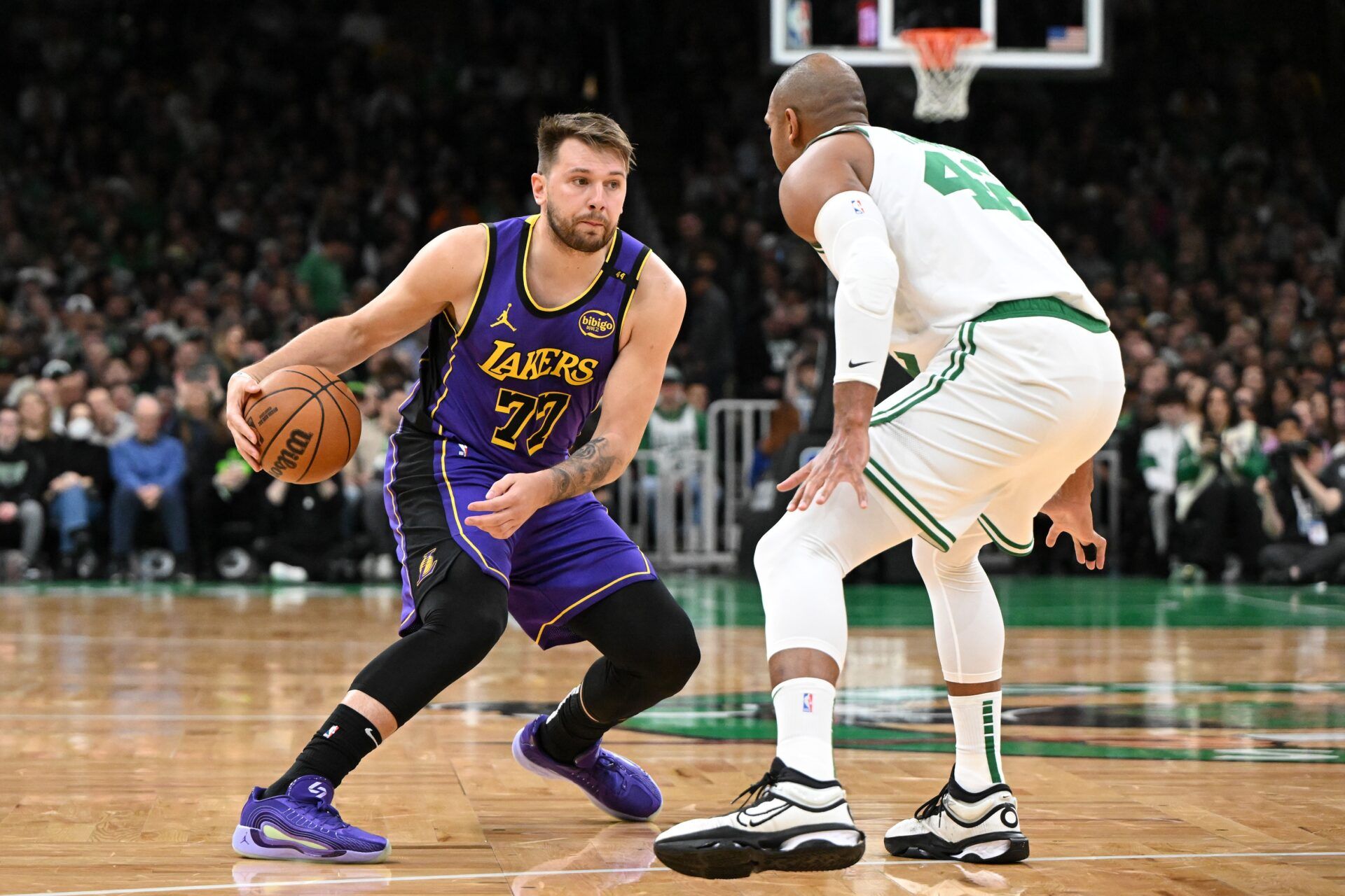 Los Angeles Lakers guard Luka Doncic (77) dribbles the ball against Boston Celtics center Al Horford (42) during the first quarter at the TD Garden.