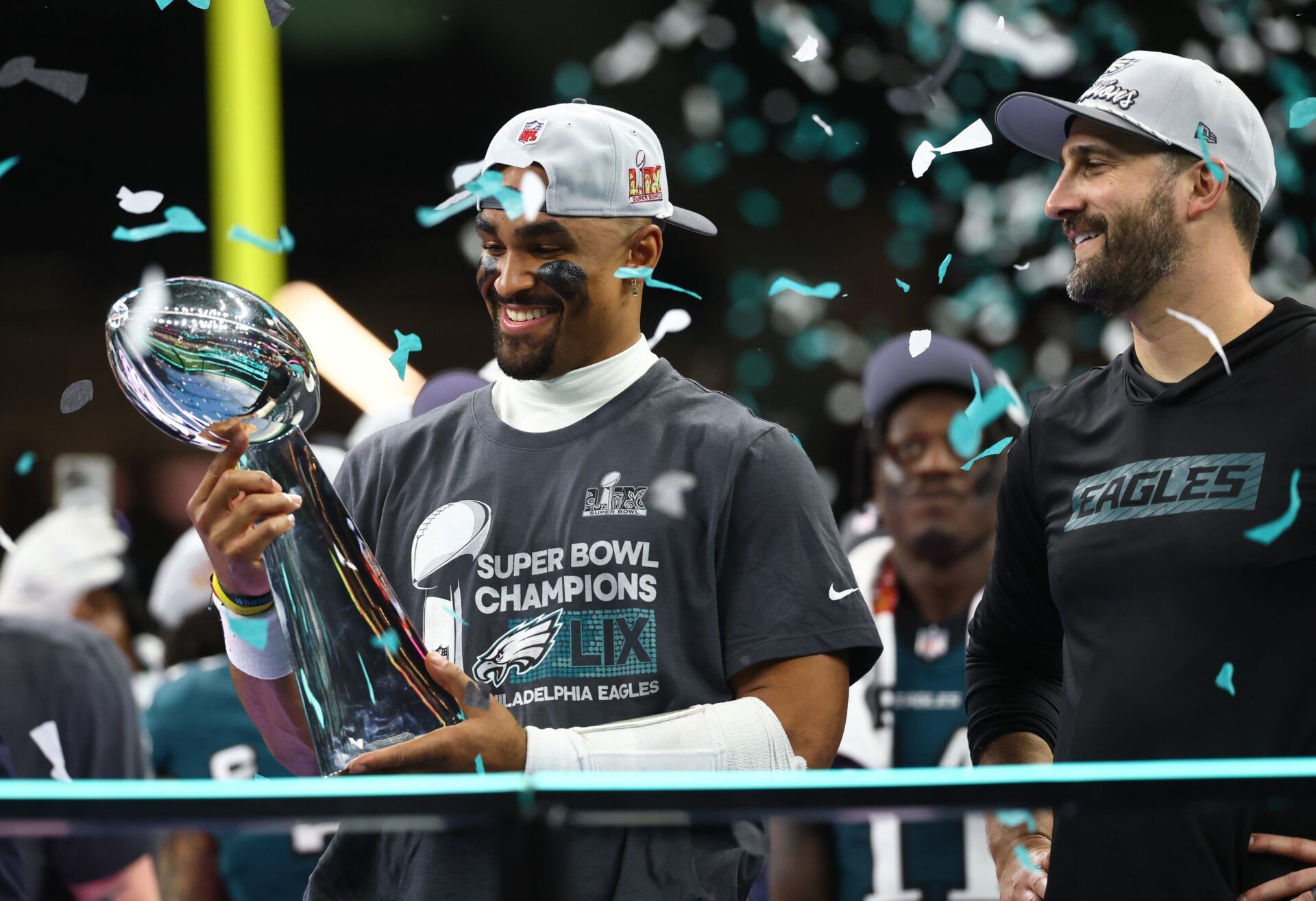 Philadelphia Eagles quarterback Jalen Hurts (1) holds the Vince Lombardi Trophy as Philadelphia Eagles head coach Nick Sirianni looks on after defeating the Kansas City Chiefs in Super Bowl 59 at Caesars Superdome.