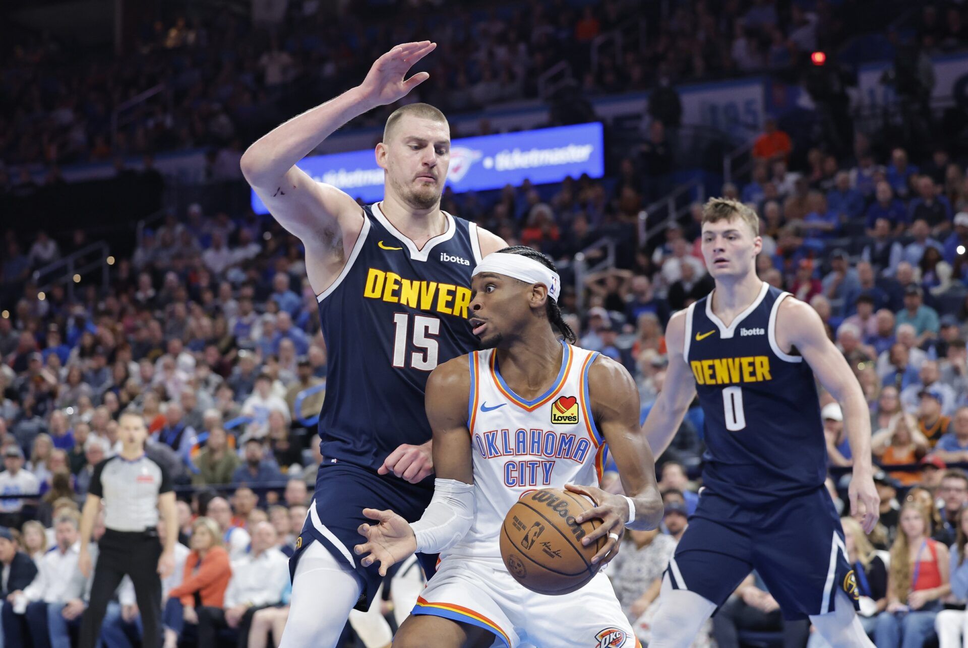 Denver Nuggets center Nikola Jokic (15) defends a drive by Oklahoma City Thunder guard Shai Gilgeous-Alexander (2) during the second half at Paycom Center.