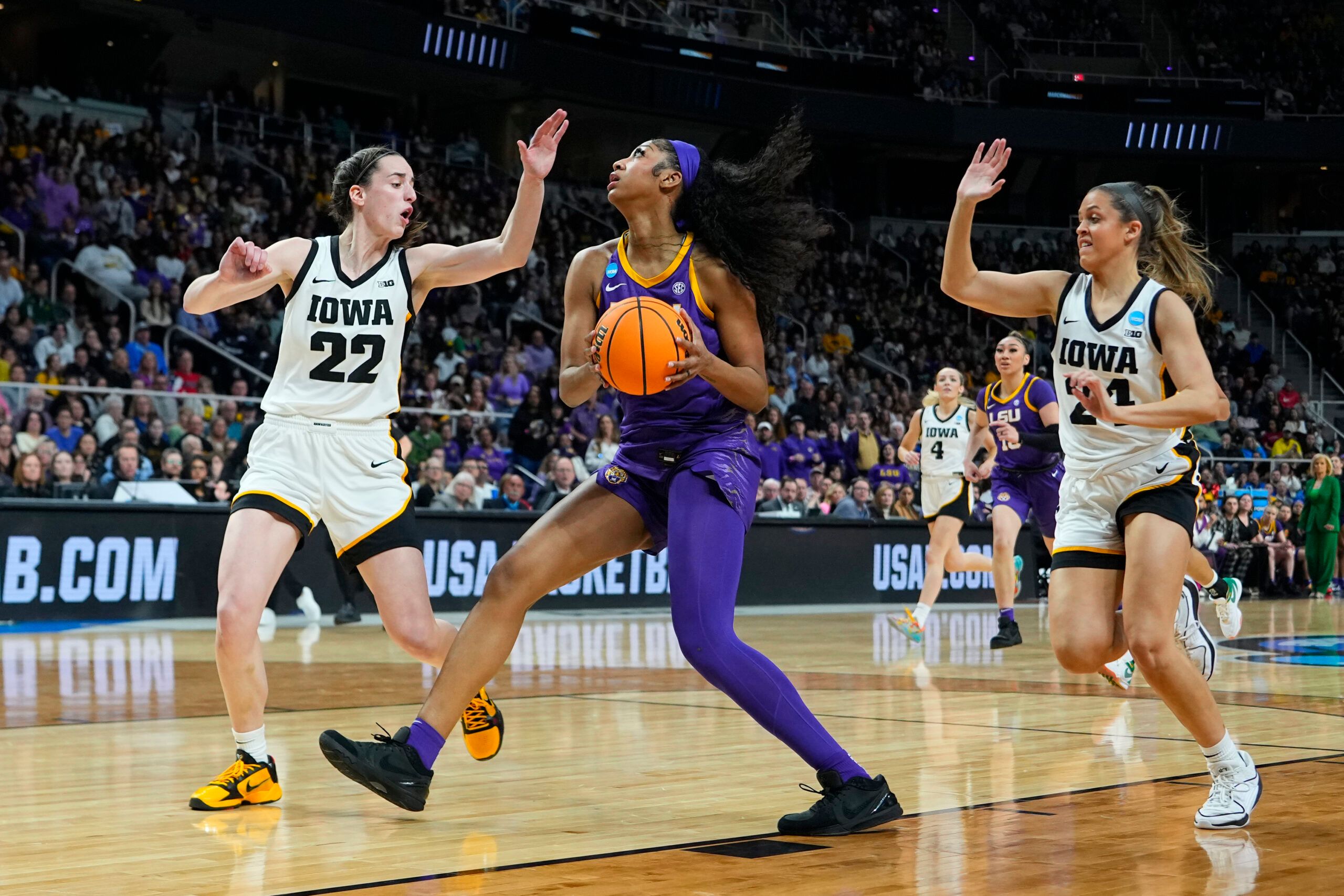 LSU Lady Tigers forward Angel Reese (10) controls the ball against Iowa Hawkeyes guard Caitlin Clark (22) and guard Gabbie Marshall (24) in the first half in the finals of the Albany Regional in the 2024 NCAA Tournament at MVP Arena.