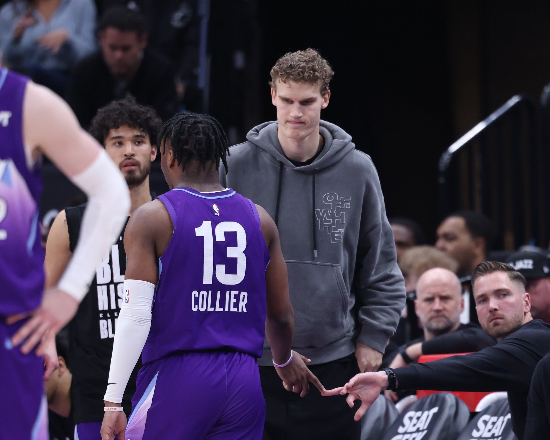 Utah Jazz forward Lauri Markkanen (right) slaps hands with guard Isaiah Collier (13) during the second half of the game against the Portland Trail Blazers at Delta Center.