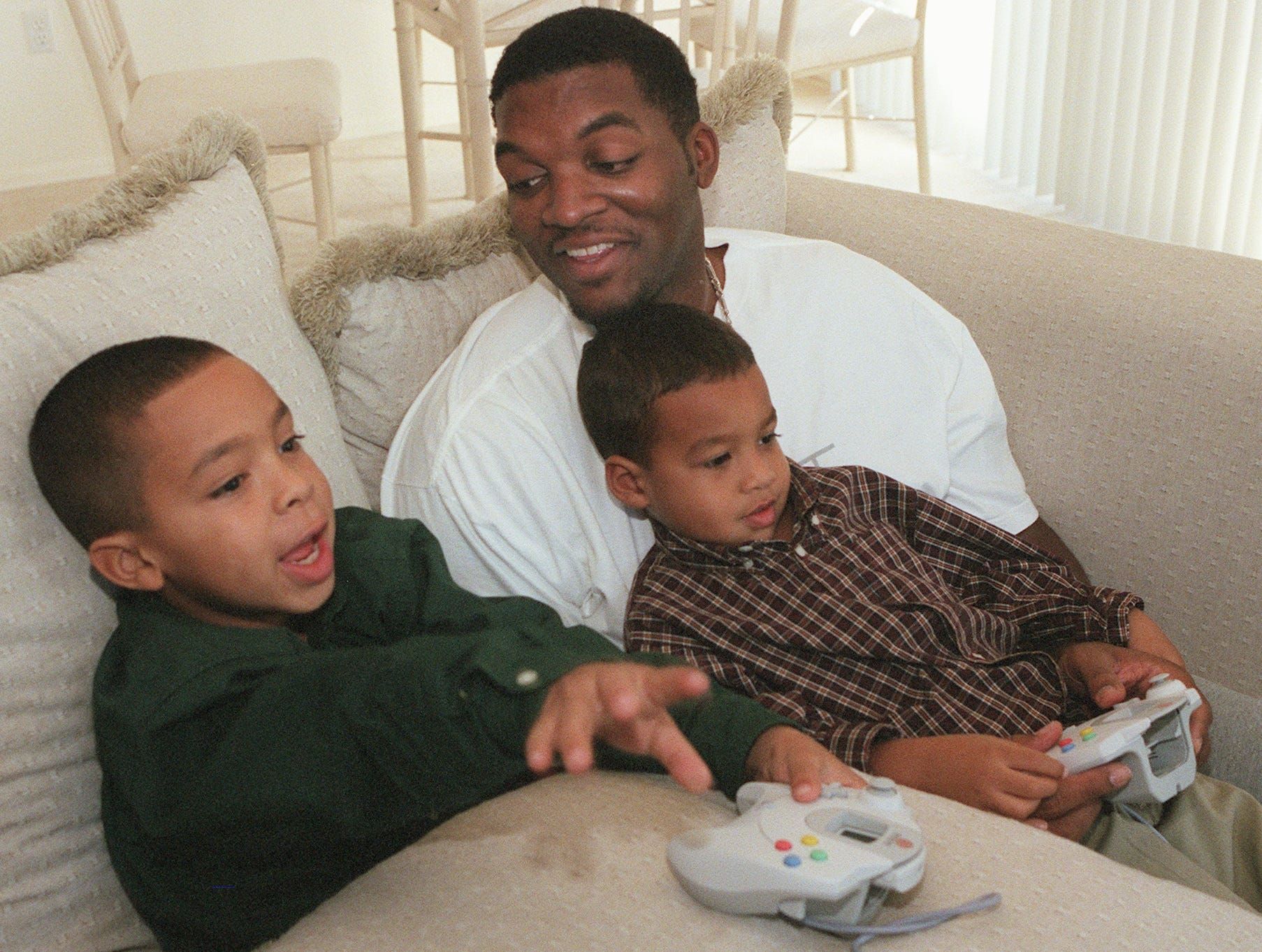 Suns center Oliver Miller plays with his boys Amman (in lap), 4, and Xavier, 8, in his Phoenix home in 1999.