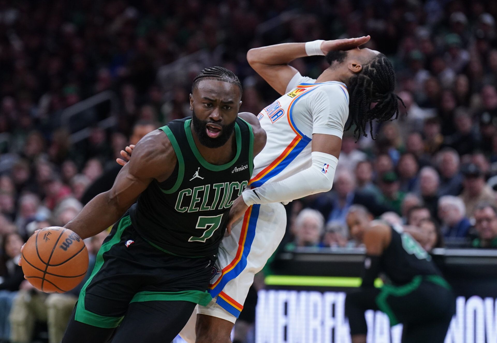 Mar 12, 2025; Boston, Massachusetts, USA; Boston Celtics guard Jaylen Brown (7) drives the ball against Oklahoma City Thunder guard Isaiah Joe (11) in the second quarter at TD Garden. Mandatory Credit: David Butler II-Imagn Images