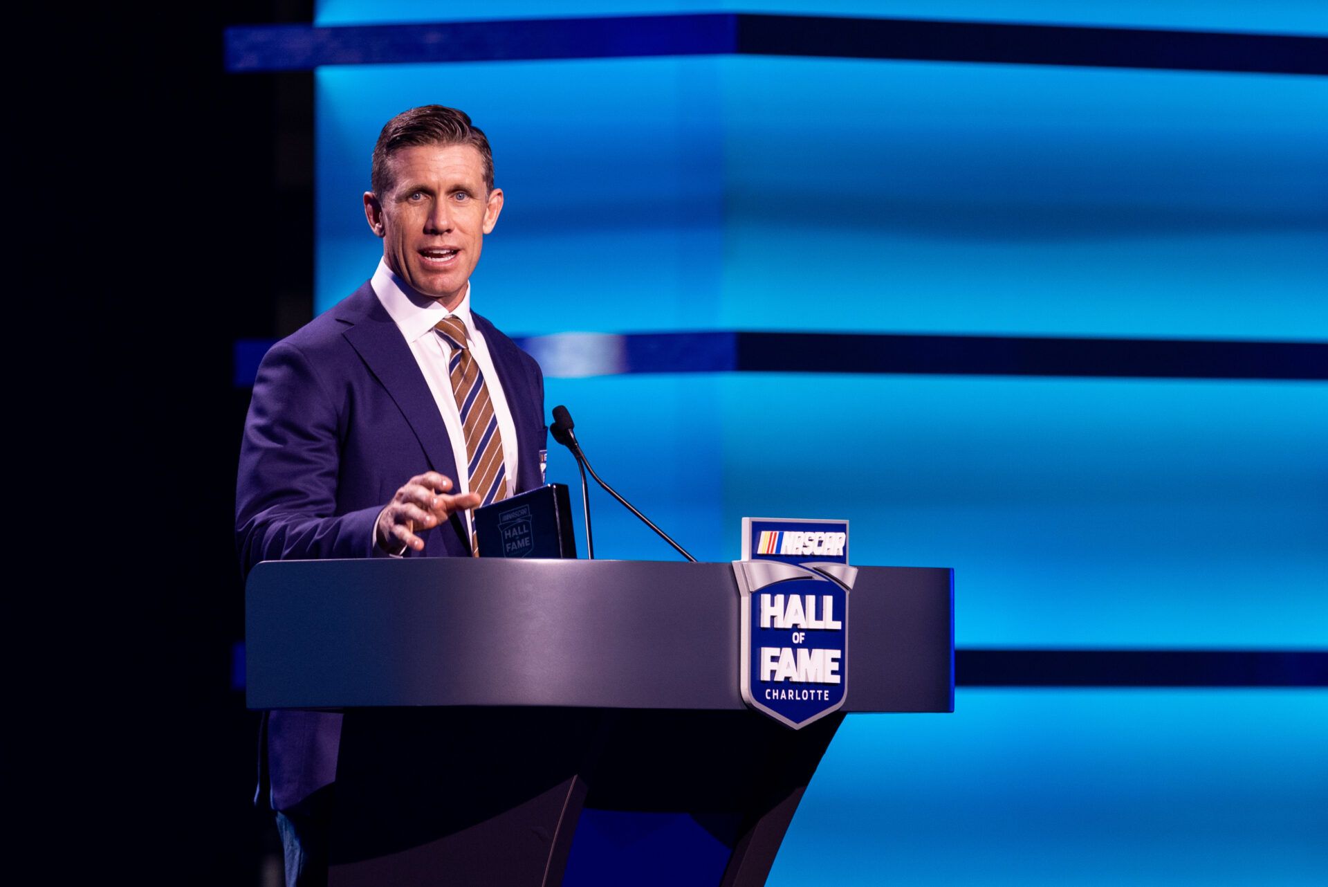 Feb 7, 2025; Charlotte, NC, USA; Former driver Carl Edwards accepts his induction into the NASCAR Hall Of Fame at Charlotte Convention Center Crown Ballroom. Mandatory Credit: Scott Kinser-Imagn Images