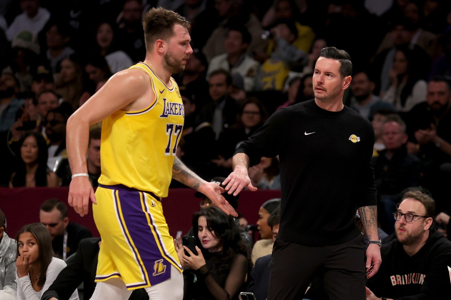 Los Angeles Lakers guard Luka Doncic (77) high fives head coach JJ Redick during the first quarter against the Brooklyn Nets at Barclays Center.