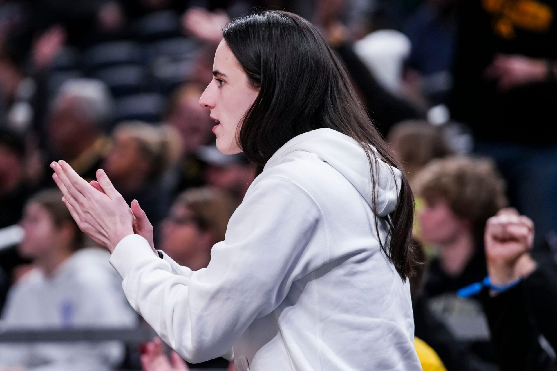 Indiana Fever guard Caitlin Clark (22) cheers on her former teammates Thursday, March 6, 2025, in a round two game at the 2025 TIAA Big Ten Women's Basketball Tournament between the Iowa Hawkeyes and the Michigan State Spartans at Gainbridge Fieldhouse in Indianapolis.