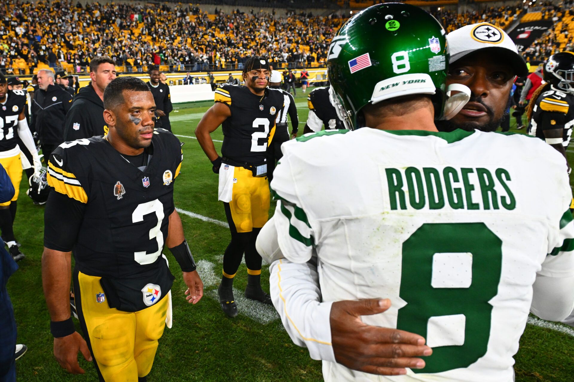 PITTSBURGH, PENNSYLVANIA - OCTOBER 20: Russell Wilson #3 and Justin Fields #2 of the Pittsburgh Steelers look on as head coach Mike Tomlin of the Pittsburgh Steelers and Aaron Rodgers #8 of the New York Jets embrace after the game at Acrisure Stadium on October 20, 2024 in Pittsburgh, Pennsylvania. (Photo by Joe Sargent/Getty Images)