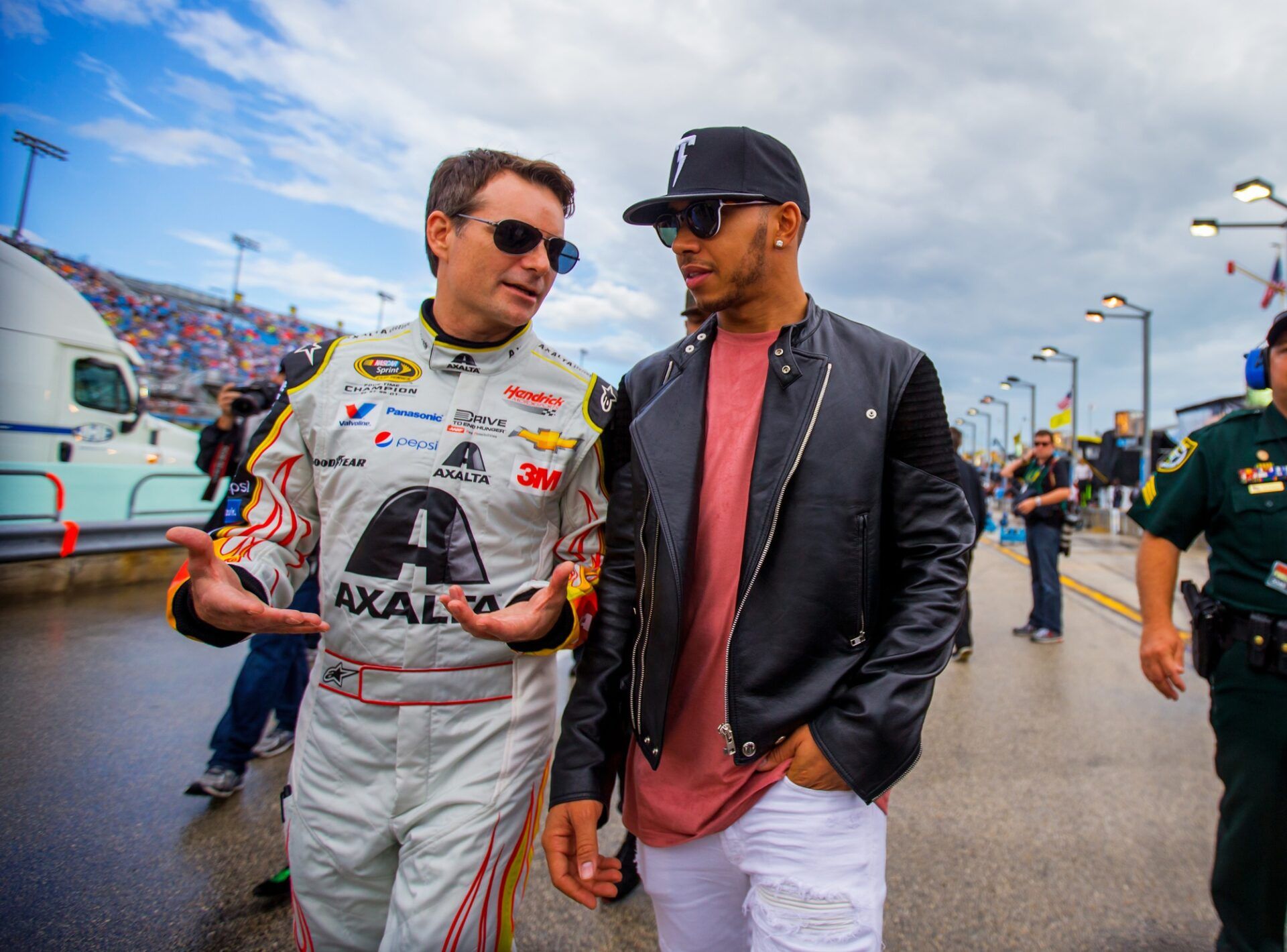 NASCAR Sprint Cup Series driver Jeff Gordon (left) walks with Formula One driver Lewis Hamilton before the Ford EcoBoost 400 at Homestead-Miami Speedway.