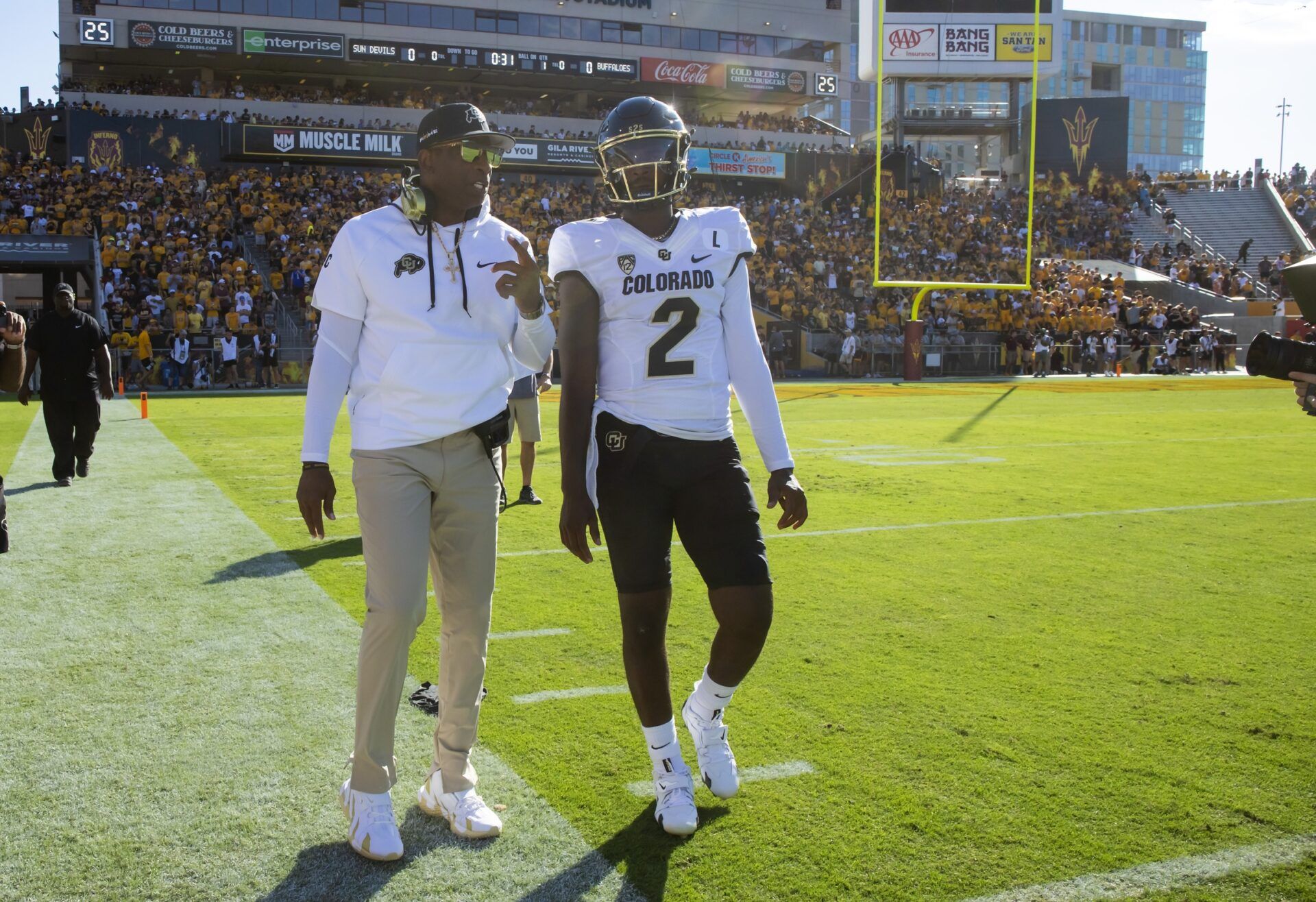 Colorado Buffaloes head coach Deion Sanders with son and quarterback Shedeur Sanders (2) against the Arizona State Sun Devils at Mountain America Stadium.