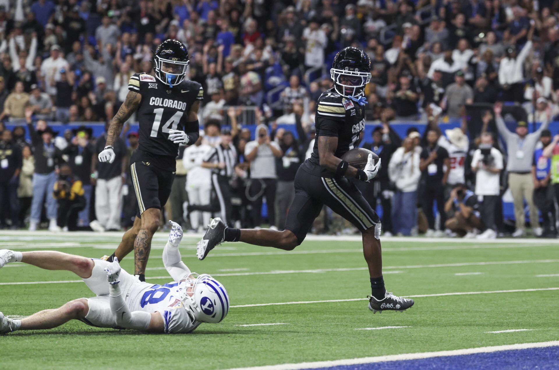 Colorado Buffaloes wide receiver Travis Hunter (12) runs with the ball and scores a touchdown during the third quarter against the Brigham Young Cougars at Alamodome.