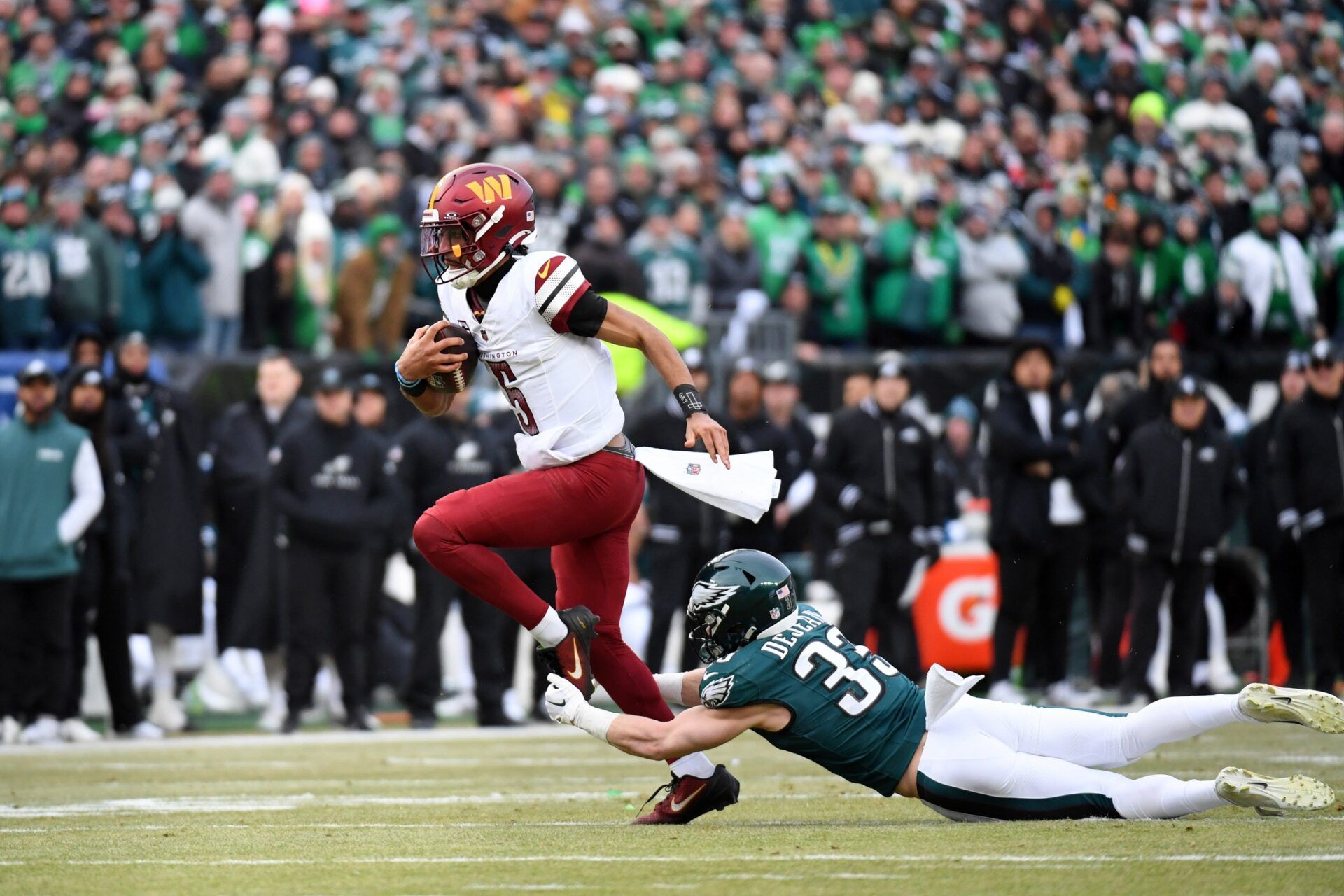 Philadelphia Eagles cornerback Cooper DeJean (33) tackles Washington Commanders quarterback Jayden Daniels (5) during the first half in the NFC Championship game at Lincoln Financial Field.