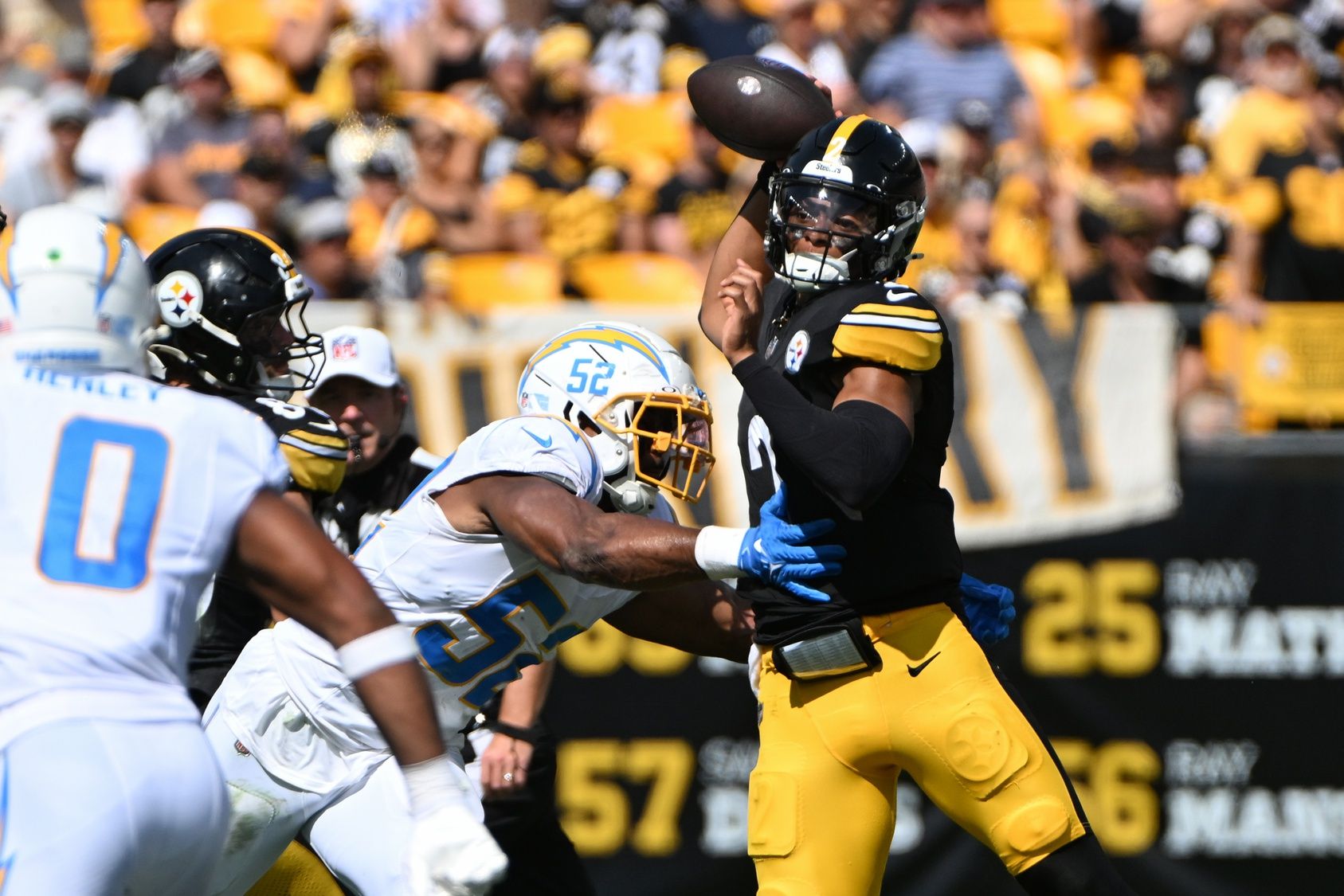 Pittsburgh Steelers quarterback Justin Fields (2) throws a pass while under pressure from Los Angeles Chargers linebacker Khalil Mack (52) during the second quarter at Acrisure Stadium.