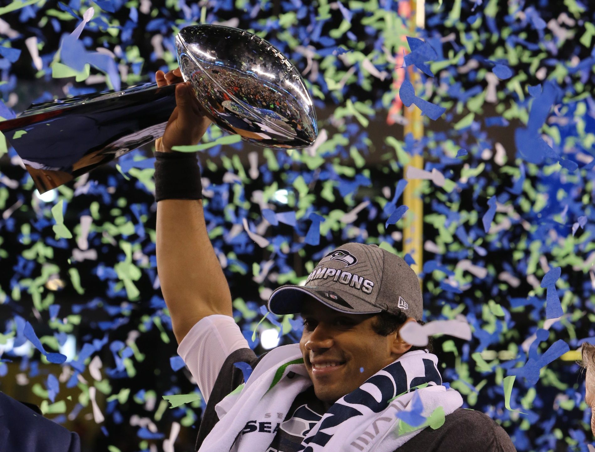 Seattle Seahawks QB Russell Wilson hoists Super Bowl trophy during celebration following Super Bowl XLVIII at MetLife Stadium.