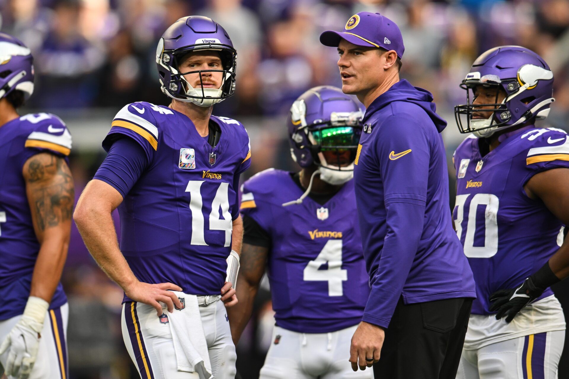 Minnesota Vikings quarterback Sam Darnold (14) and Minnesota Vikings head coach Kevin O'Connell and fullback C.J. Ham (right) look on before the game against the Detroit Lions at U.S. Bank Stadium.
