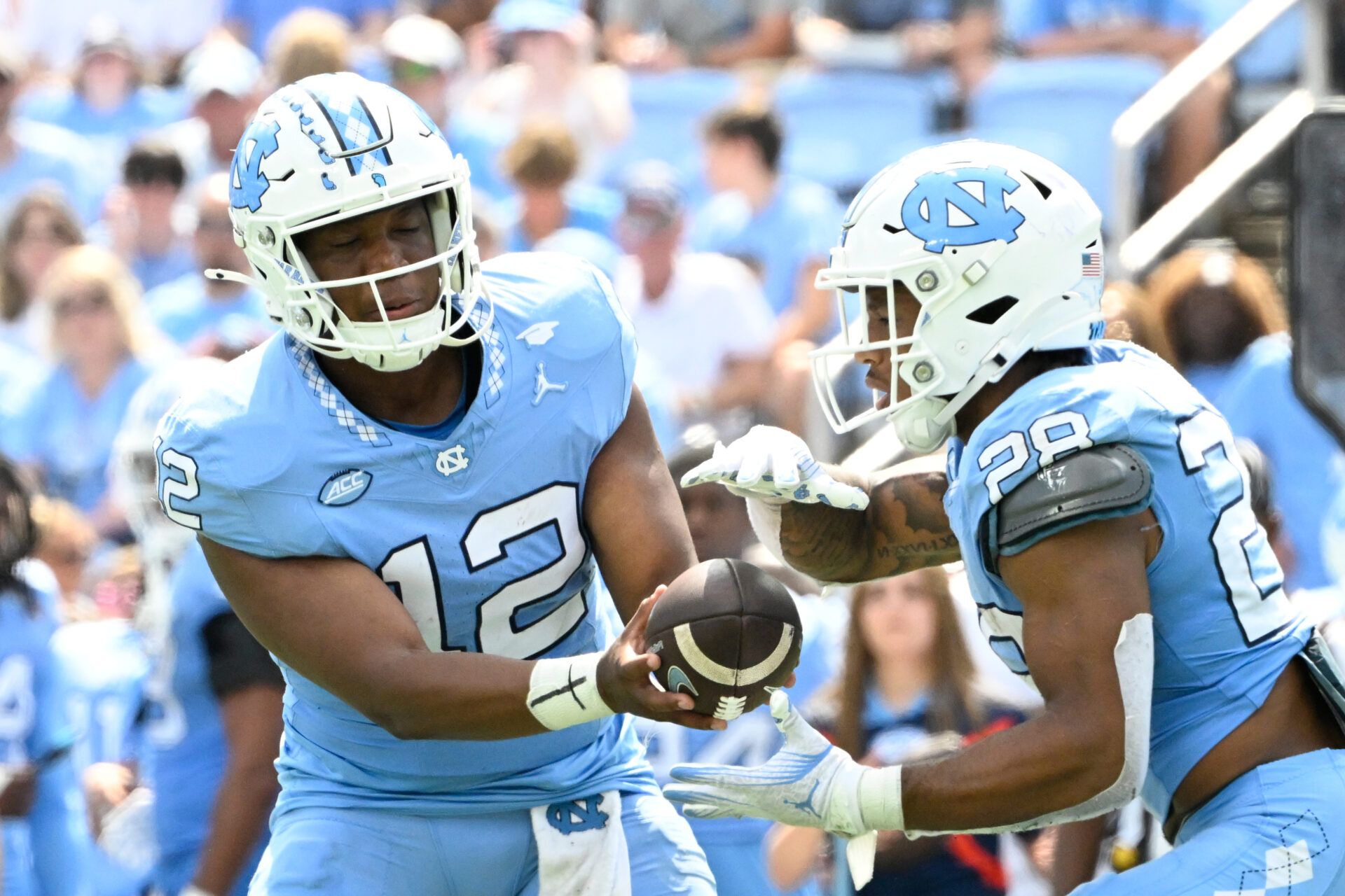 Sep 21, 2024; Chapel Hill, North Carolina, USA; North Carolina Tar Heels quarterback Jacolby Criswell (12) hands the ball off to running back Omarion Hampton (28) in the second quarter at Kenan Memorial Stadium. Mandatory Credit: Bob Donnan-Imagn Images