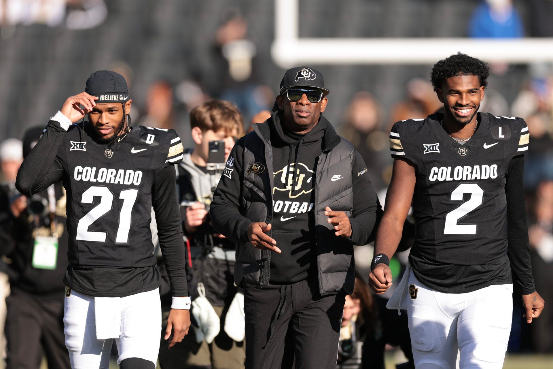 BOULDER, COLORADO - NOVEMBER 29: (L-R) Shilo Sanders #21, Head coach Deion Sanders and Shedeur Sanders #2 of the Colorado Buffaloes walk the field during senior day celebrations prior to the game against the Oklahoma State Cowboys at Folsom Field on November 29, 2024 in Boulder, Colorado. (Photo by Andrew Wevers/Getty Images)