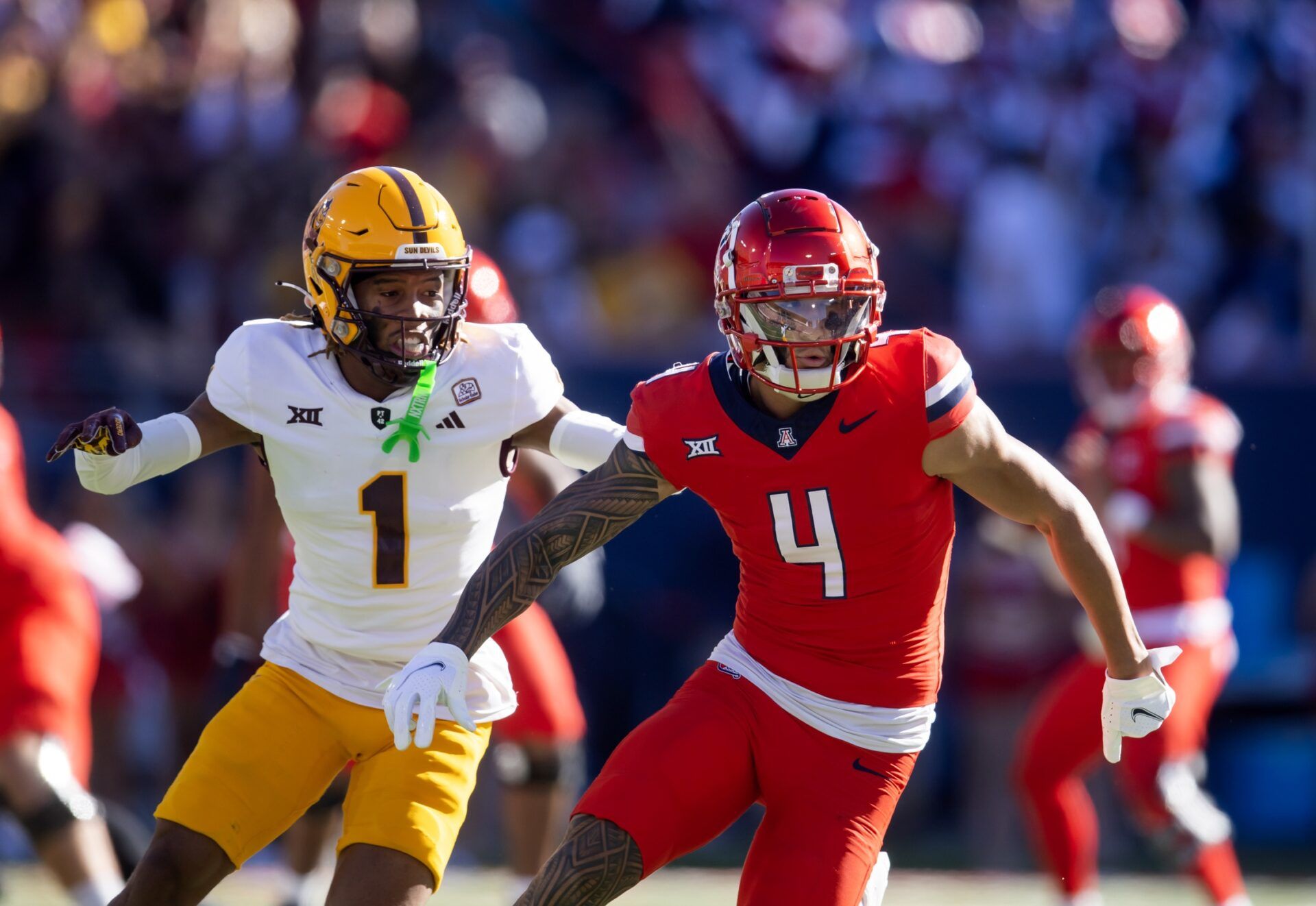 Arizona Wildcats wide receiver Tetairoa McMillan (4) against Arizona State Sun Devils defensive back Keith Abney II (1) during the Territorial Cup at Arizona Stadium.