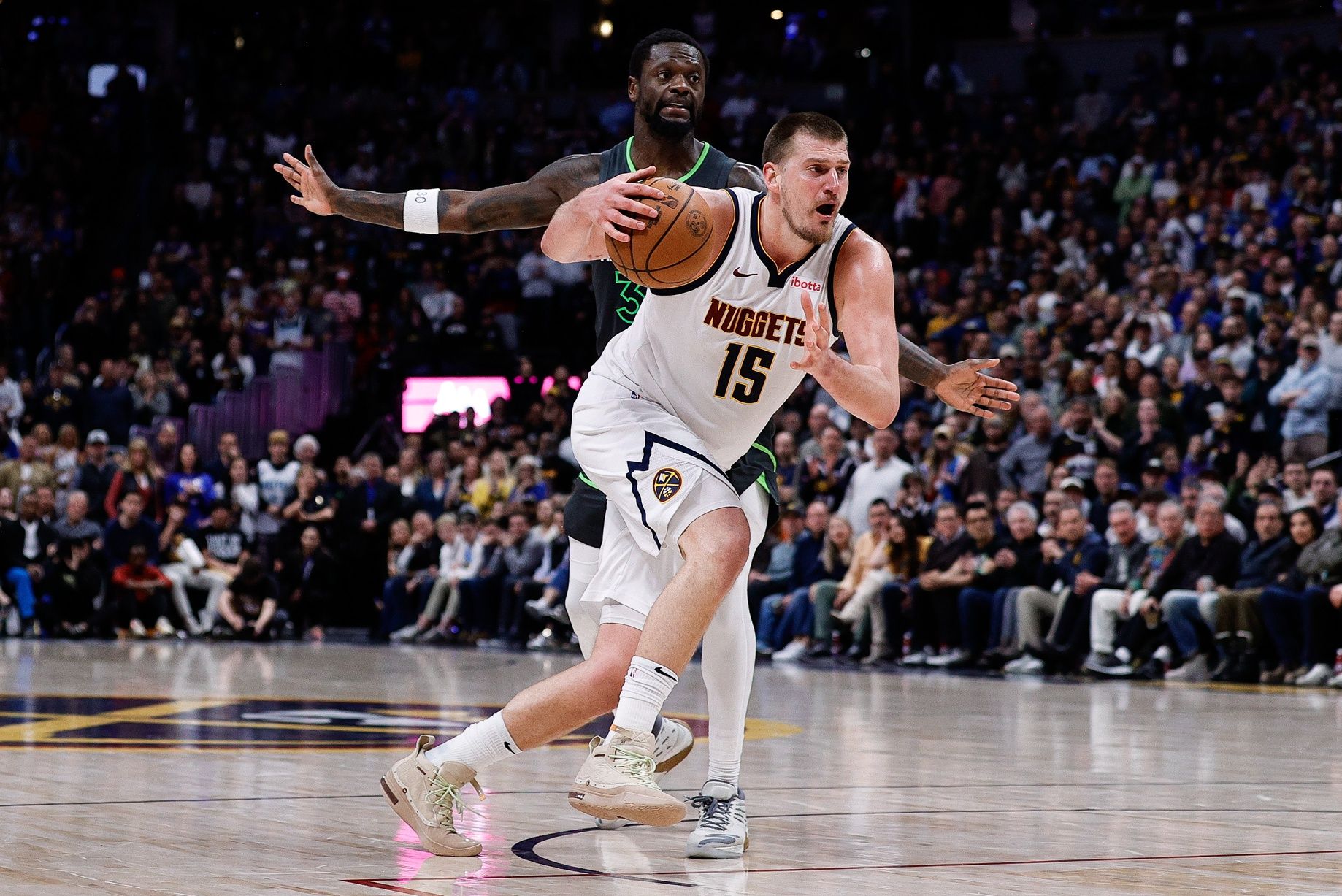 Denver Nuggets center Nikola Jokic (15) drives to the basket against Minnesota Timberwolves forward Julius Randle (30) in the fourth quarter at Ball Arena.