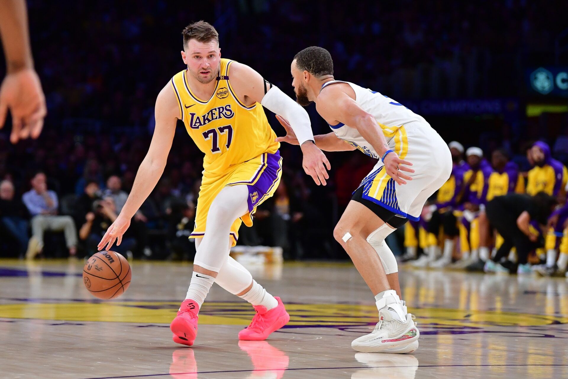 Los Angeles Lakers guard Luka Doncic (77) moves the ball against Golden State Warriors guard Stephen Curry (30) during the first half at Crypto.com Arena.