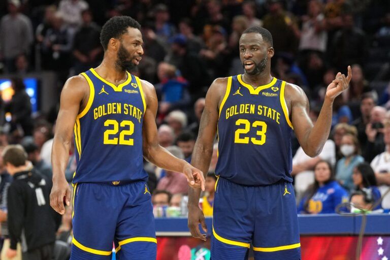 Golden State Warriors forwards Andrew Wiggins (22) and Draymond Green (23) talk during overtime against the Los Angeles Lakers at Chase Center.