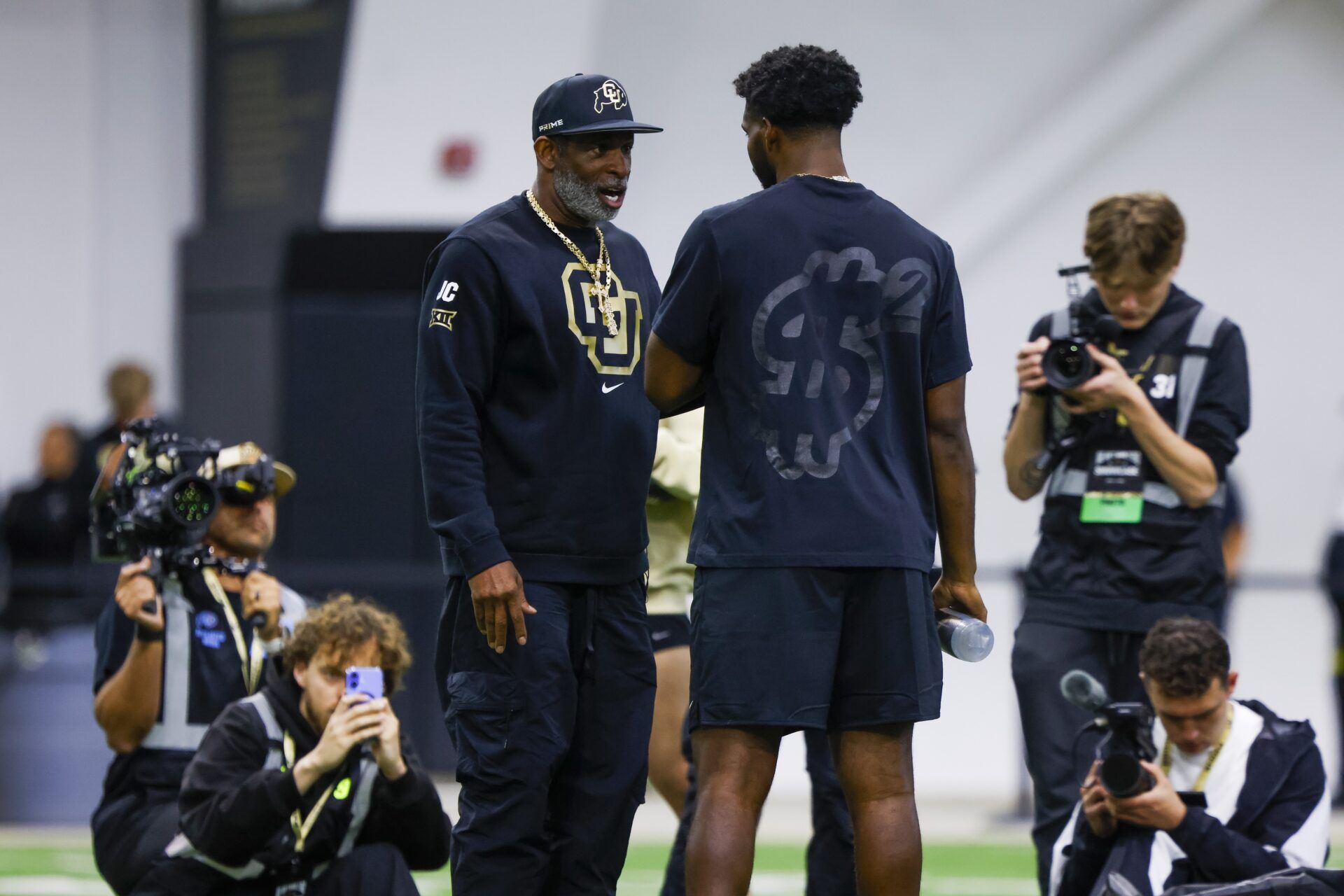 Colorado Buffaloes head coach Deion Sanders talks to his son, Colorado Buffaloes quarterback Shedeur Sanders (2), at the University of Colorado NFL Showcase at the CU Indoor Practice Facility. Colorado Buffaloes head coach Deion Sanders talks to his son, Colorado Buffaloes quarterback Shedeur Sanders (2), at the University of Colorado NFL Showcase at the CU Indoor Practice Facility.