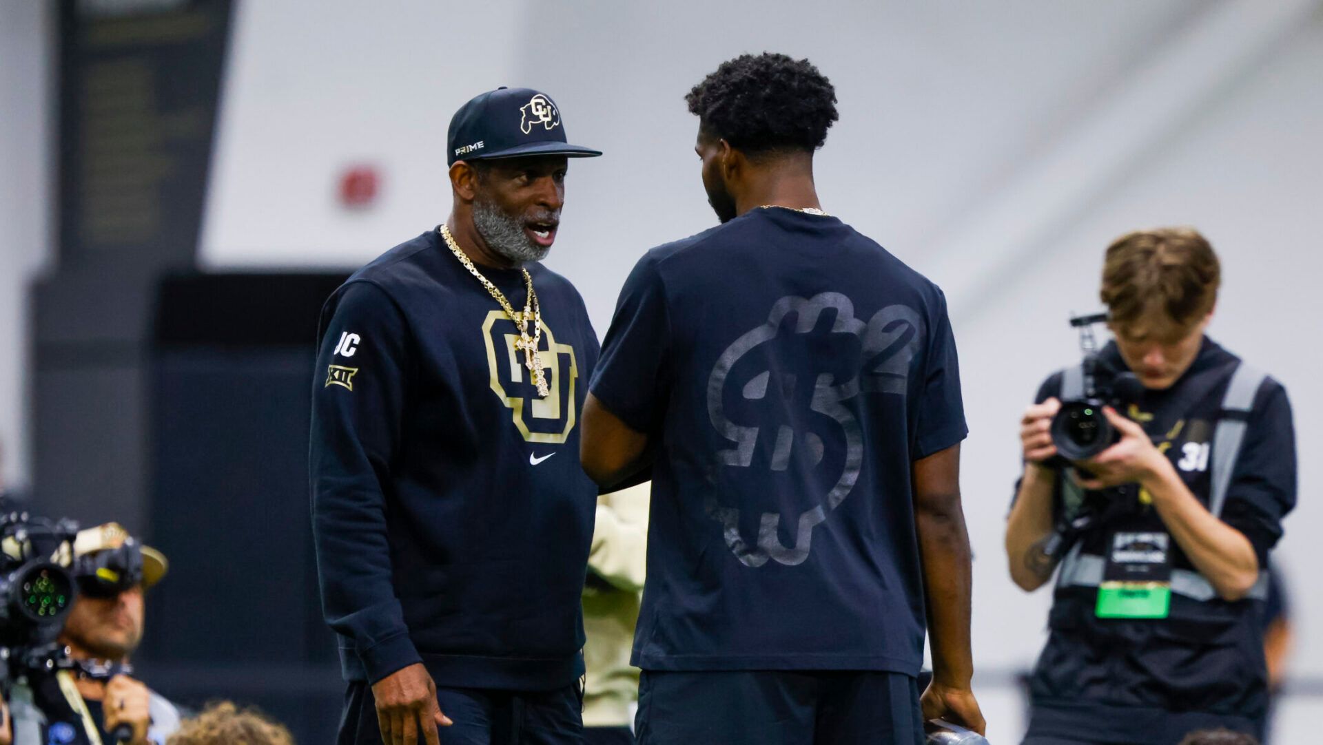 Apr 4, 2025; Boulder, CO, USA; Colorado Buffaloes head coach Deion Sanders talks to his son, Colorado Buffaloes quarterback Shedeur Sanders (2), at the University of Colorado NFL Showcase at the CU Indoor Practice Facility. Mandatory Credit: Michael Ciaglo-Imagn Images