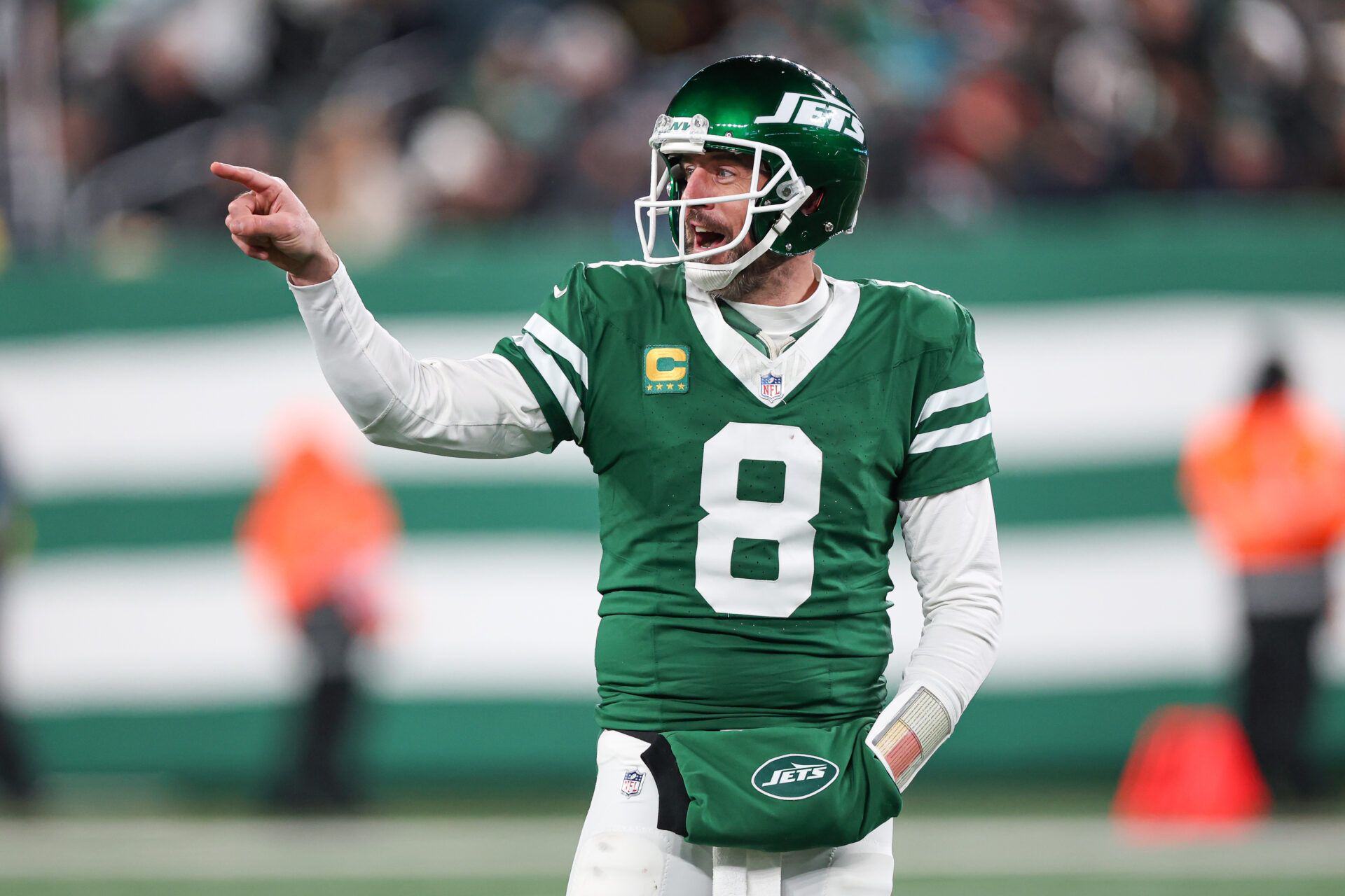 Jan 5, 2025; East Rutherford, New Jersey, USA; New York Jets quarterback Aaron Rodgers (8) gestures towards the Miami Dolphins bench during the second half at MetLife Stadium. Mandatory Credit: Vincent Carchietta-Imagn Images