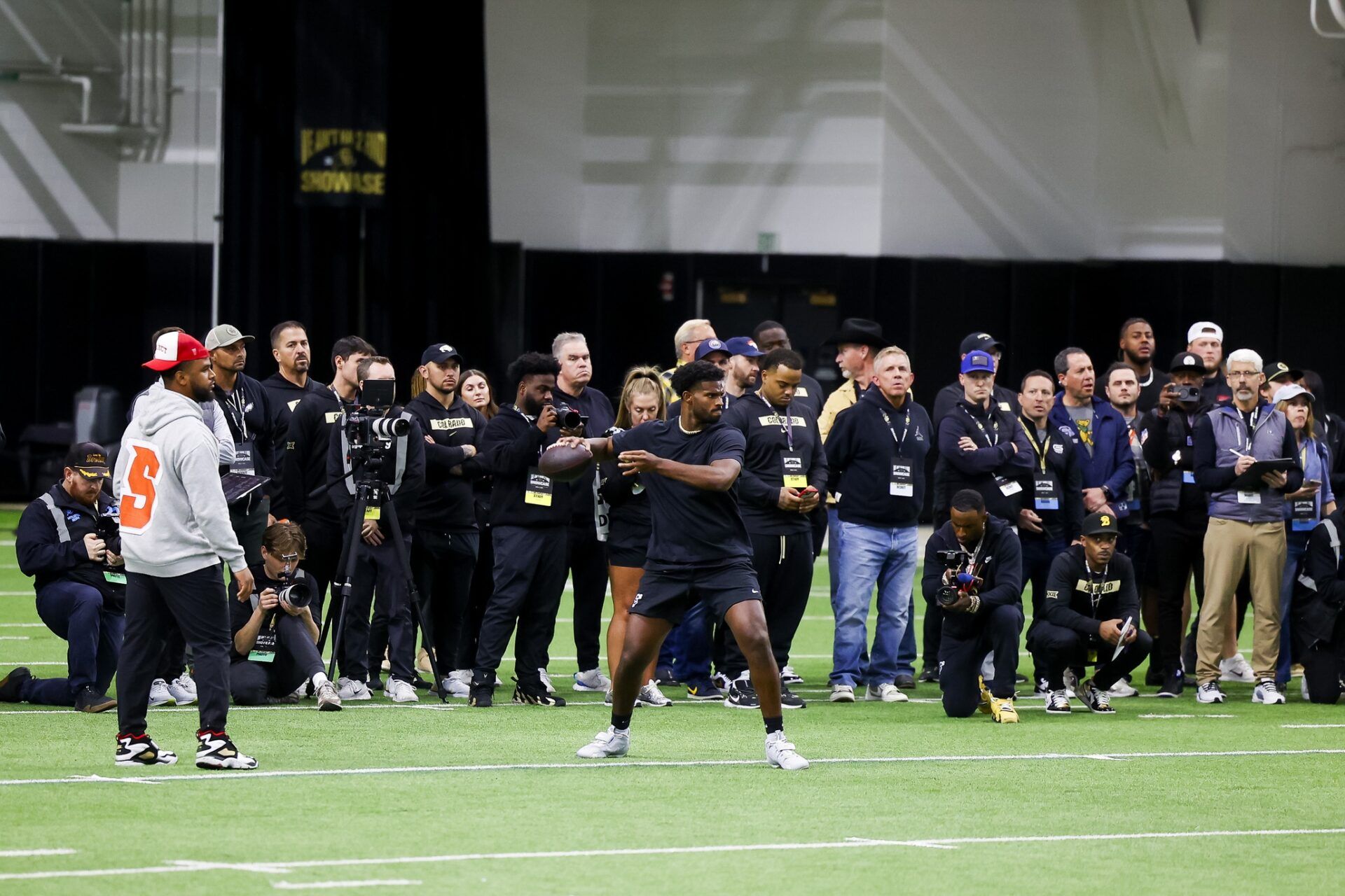 People watch as Colorado Buffaloes quarterback Shedeur Sanders (2) throws passes at the University of Colorado NFL Showcase at the CU Indoor Practice Facility.