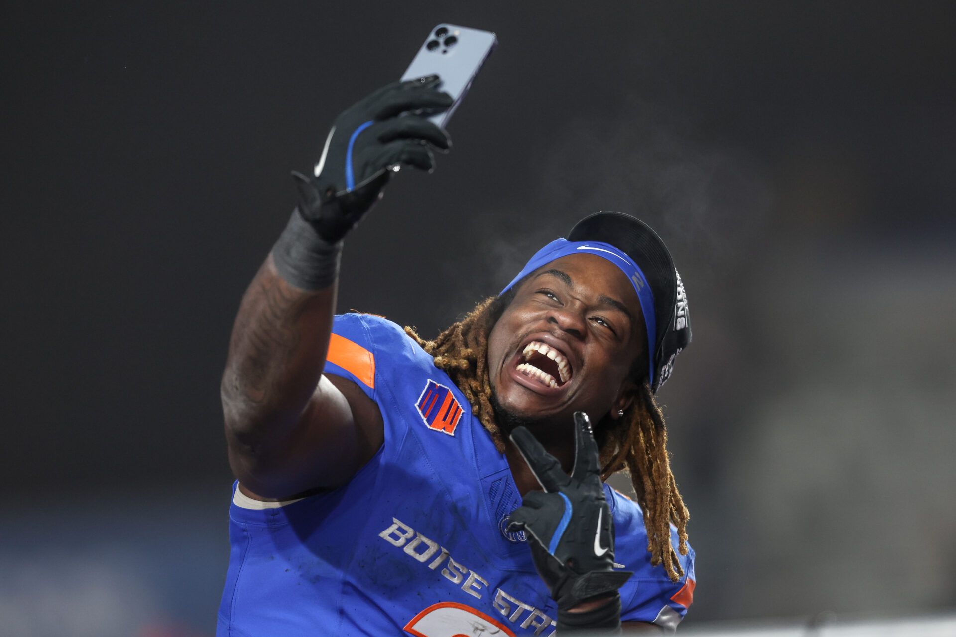 BOISE, ID - DECEMBER 06: Running back Ashton Jeanty #2 of the Boise State Broncos celebrates a win and being named the offensive player of the game with a selfie at the conclusion of the second half of the Mountain West Championship against the UNLV Rebels at Albertsons Stadium on December 06, 2024 in Boise, Idaho. Boise State won the game 21-7. Jeanty moves into fourth place in FBS history for most rushing yards in a single season, 131 yards away from tying with Barry Sanders' 1988 single-season rushing record. (Photo by Loren Orr/Getty Images