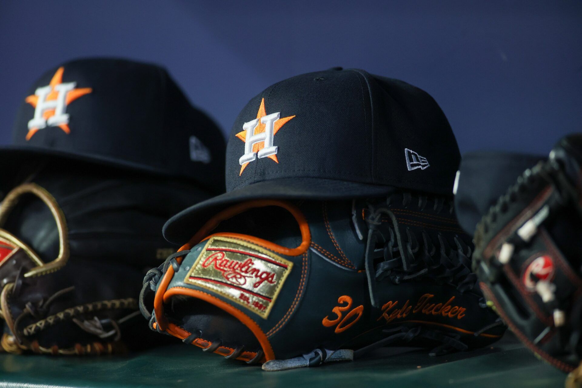 A detailed view of a Houston Astros hat and glove in the dugout against the Atlanta Braves in the fifth inning at Truist Park.