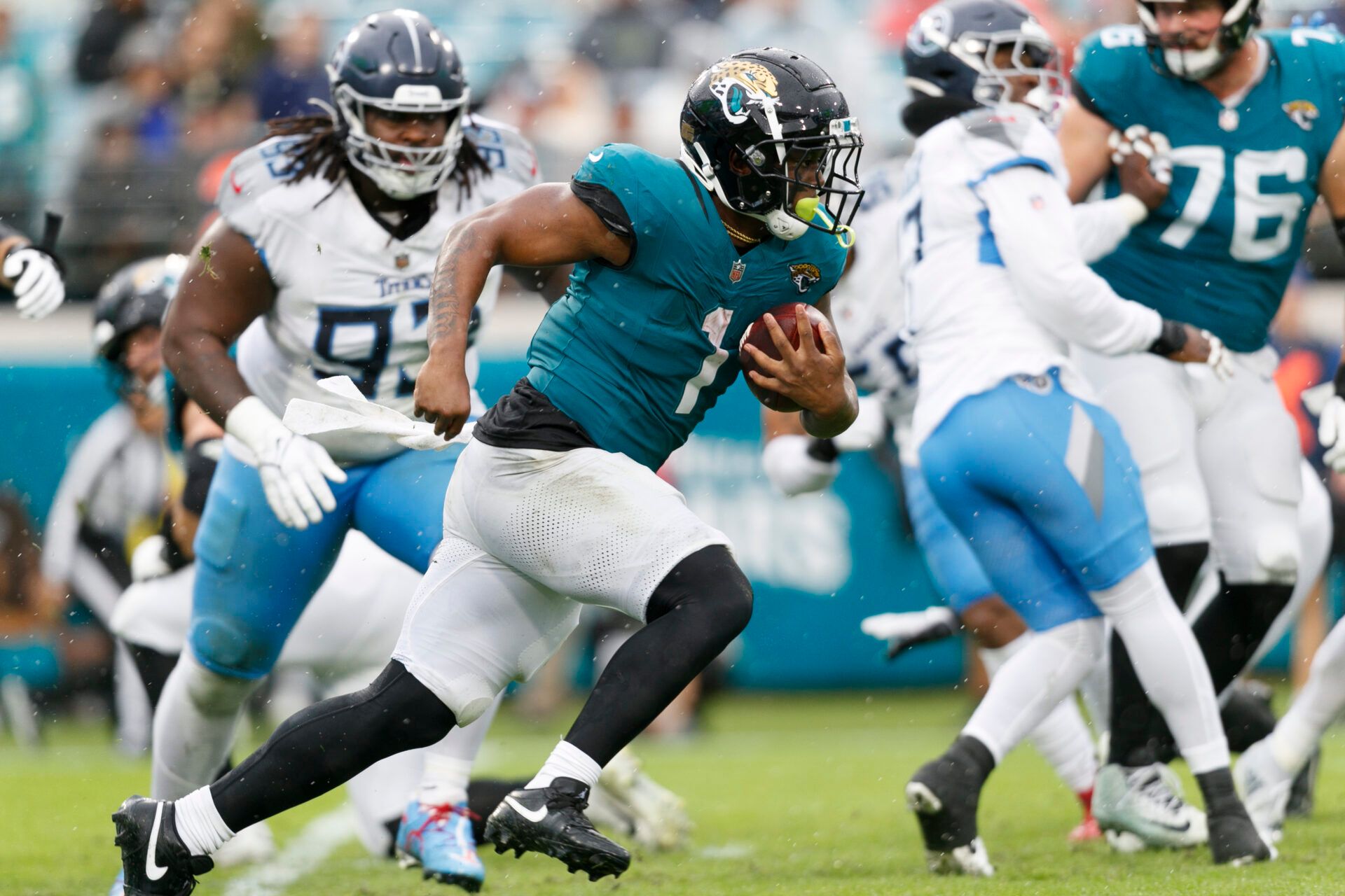 Dec 29, 2024; Jacksonville, Florida, USA; Jacksonville Jaguars running back Travis Etienne Jr. (1) runs the ball past Tennessee Titans nose tackle T'Vondre Sweat (93) during the first quarter at EverBank Stadium. Mandatory Credit: Morgan Tencza-Imagn Images