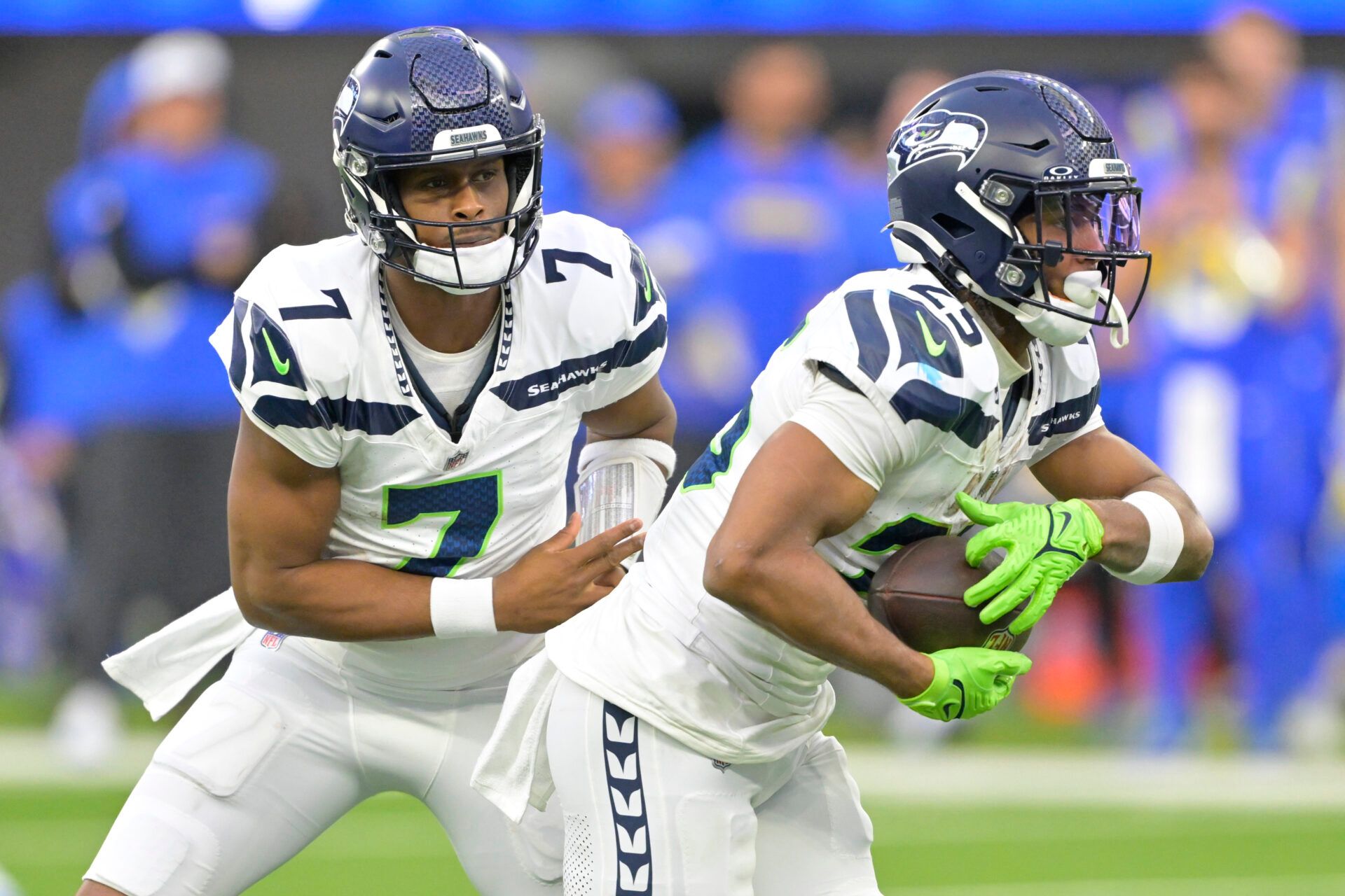 Jan 5, 2025; Inglewood, California, USA; Seattle Seahawks quarterback Geno Smith (7) hands off to running back Kenny McIntosh (25) against the Los Angeles Rams at SoFi Stadium. Mandatory Credit: Jayne Kamin-Oncea-Imagn Images
