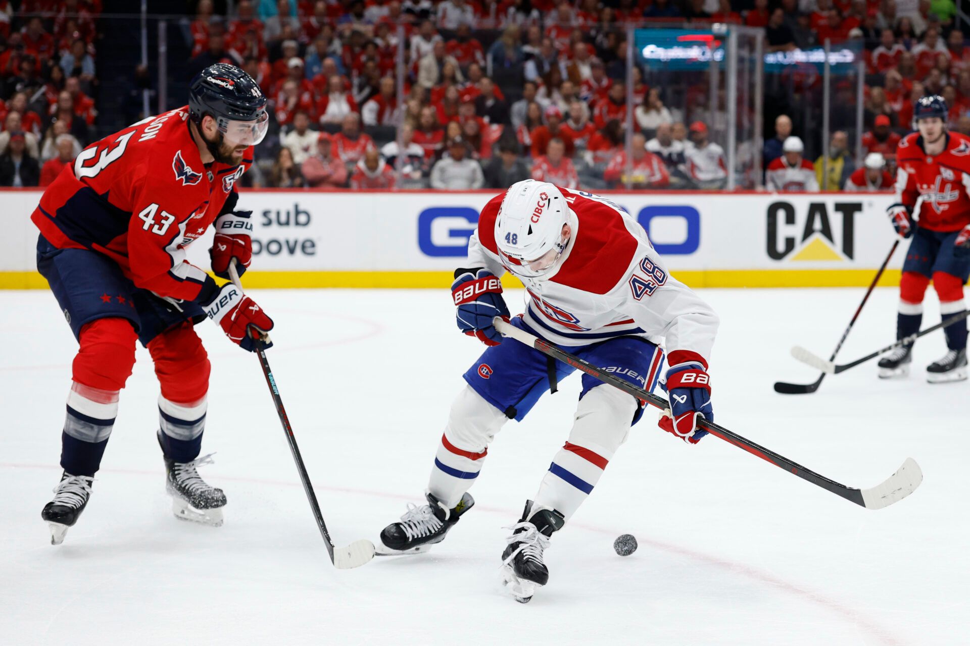 Apr 21, 2025; Washington, District of Columbia, USA; Montreal Canadiens defenseman Lane Hutson (48) attempts to control the puck in front of Washington Capitals right wing Tom Wilson (43) in the second period in game one of the first round of the 2025 Stanley Cup Playoffs at Capital One Arena. Mandatory Credit: Geoff Burke-Imagn Images