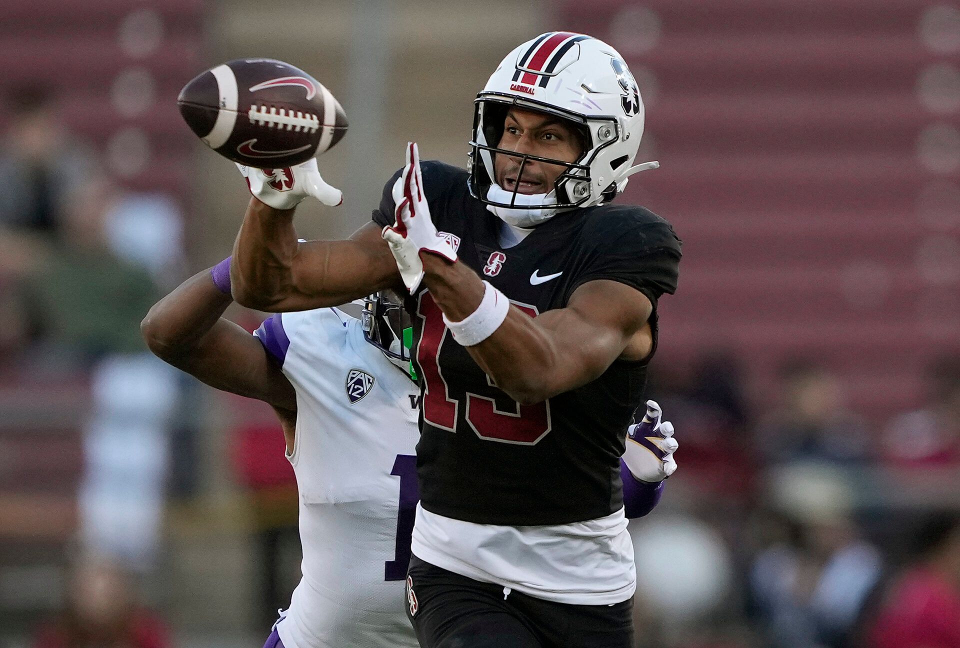 STANFORD, CALIFORNIA - OCTOBER 28: Elic Ayomanor #13 of the Stanford Cardinal catches a pass in front of Jabbar Muhammad #1 of the Washington Huskies during the second quarter at Stanford Stadium on October 28, 2023 in Stanford, California. (Photo by Thearon W. Henderson/Getty Images)