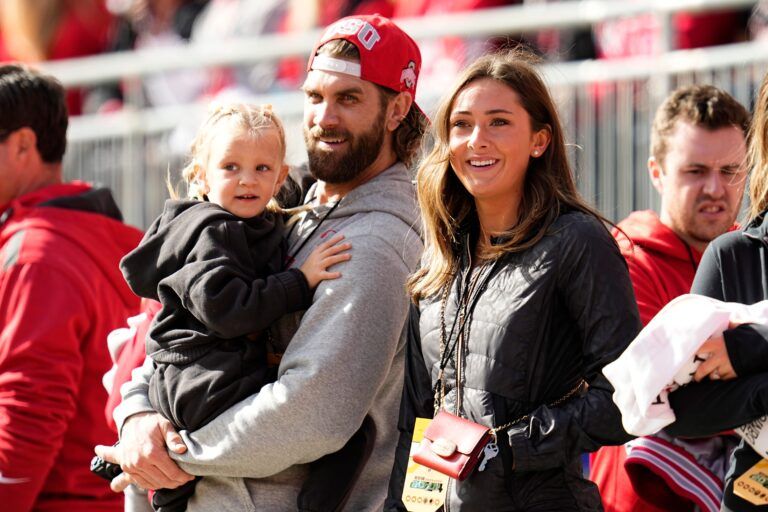 Bryce Harper and his wife, Ohio State alum Kayla Harper, watch on the sideline during the first half of the NCAA football game between the Ohio State Buckeyes and the Nebraska Cornhuskers at Ohio Stadium in Columbus on Saturday, Oct. 26, 2024.