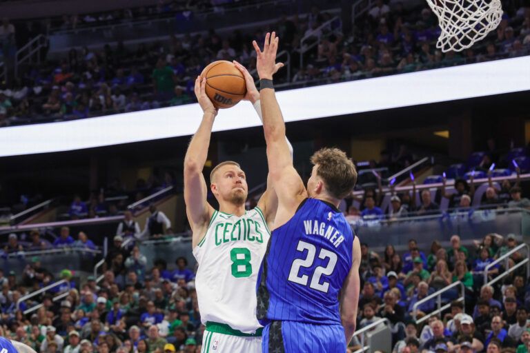 Apr 25, 2025; Orlando, Florida, USA; Boston Celtics center Kristaps Porzingis (8) shoots the ball against Orlando Magic forward Franz Wagner (22) during the second half of game three of first round for the 2024 NBA Playoffs at Kia Center. Mandatory Credit: Mike Watters-Imagn Images